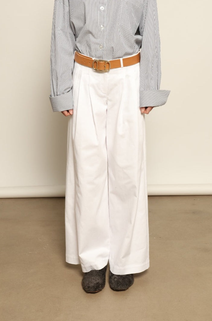 Model is wearing the Katherine White A-Line Pant by Maison Jejia, structured cotton trousers with an elongating A-line silhouette, curated in the House of Nomad Stories selection.