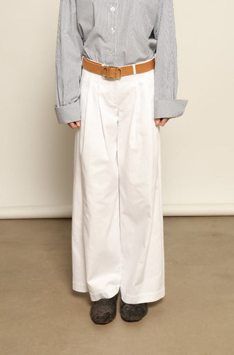 Model is wearing the Katherine White A-Line Pant by Maison Jejia, structured cotton trousers with an elongating A-line silhouette, curated in the House of Nomad Stories selection.