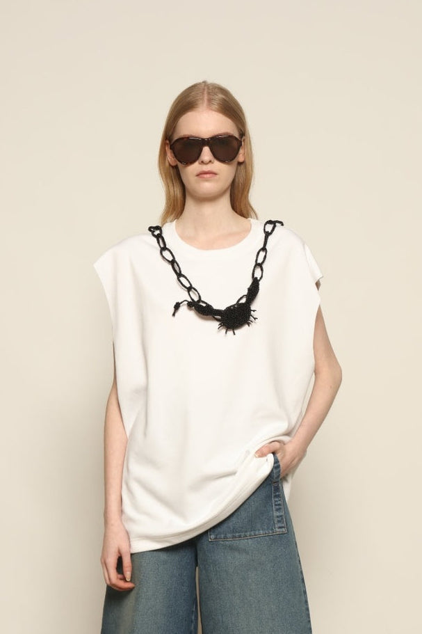 Model is wearing the Tea Cotton Jersey T-Shirt with Black Crab by Maison Jejia, a relaxed cotton tee featuring a playful beaded crab necklace detail, curated in the House of Nomad Stories selection.