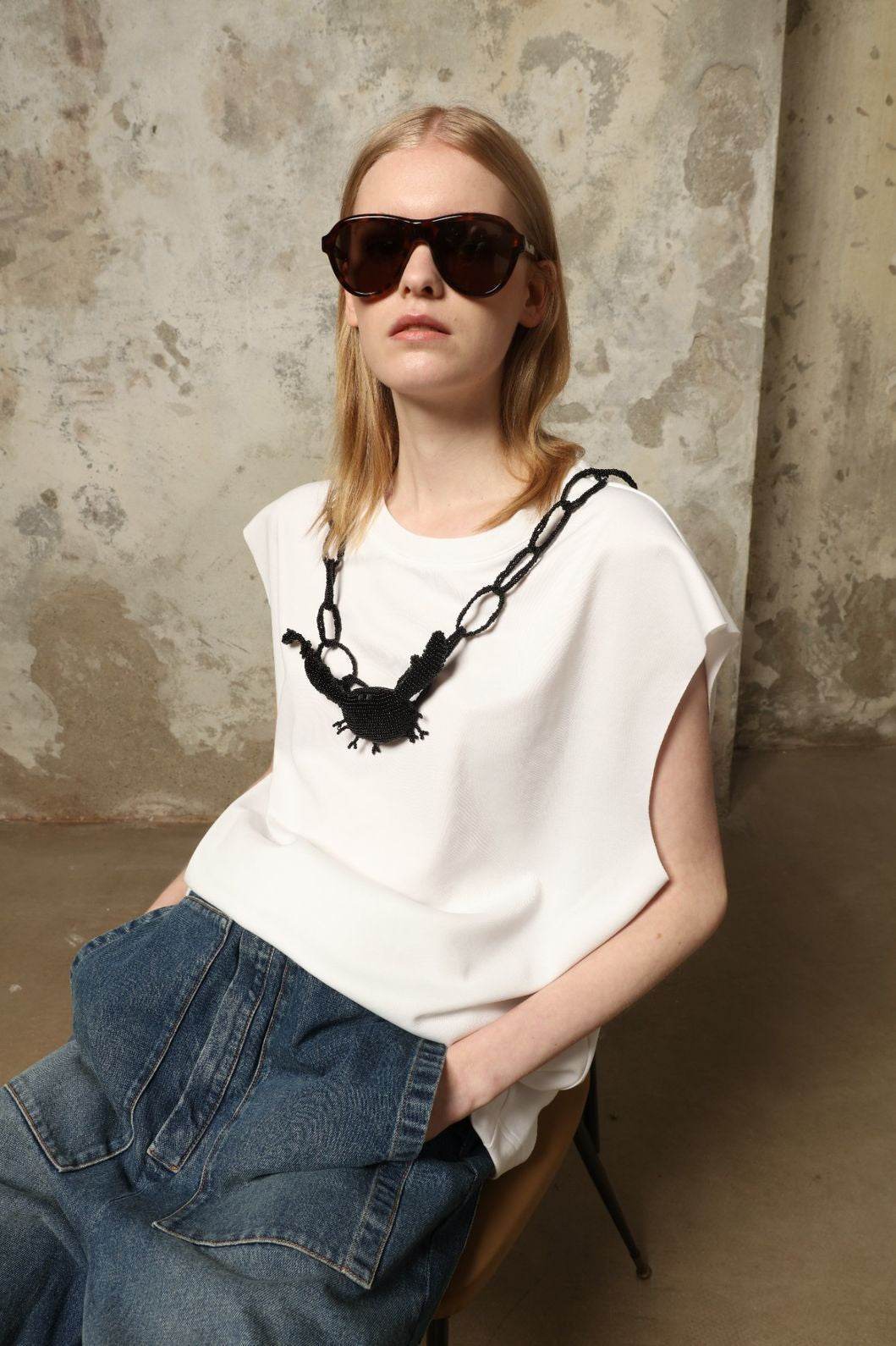 Model is wearing the Tea Cotton Jersey T-Shirt with Black Crab by Maison Jejia, a relaxed cotton tee featuring a playful beaded crab necklace detail, curated in the House of Nomad Stories selection.