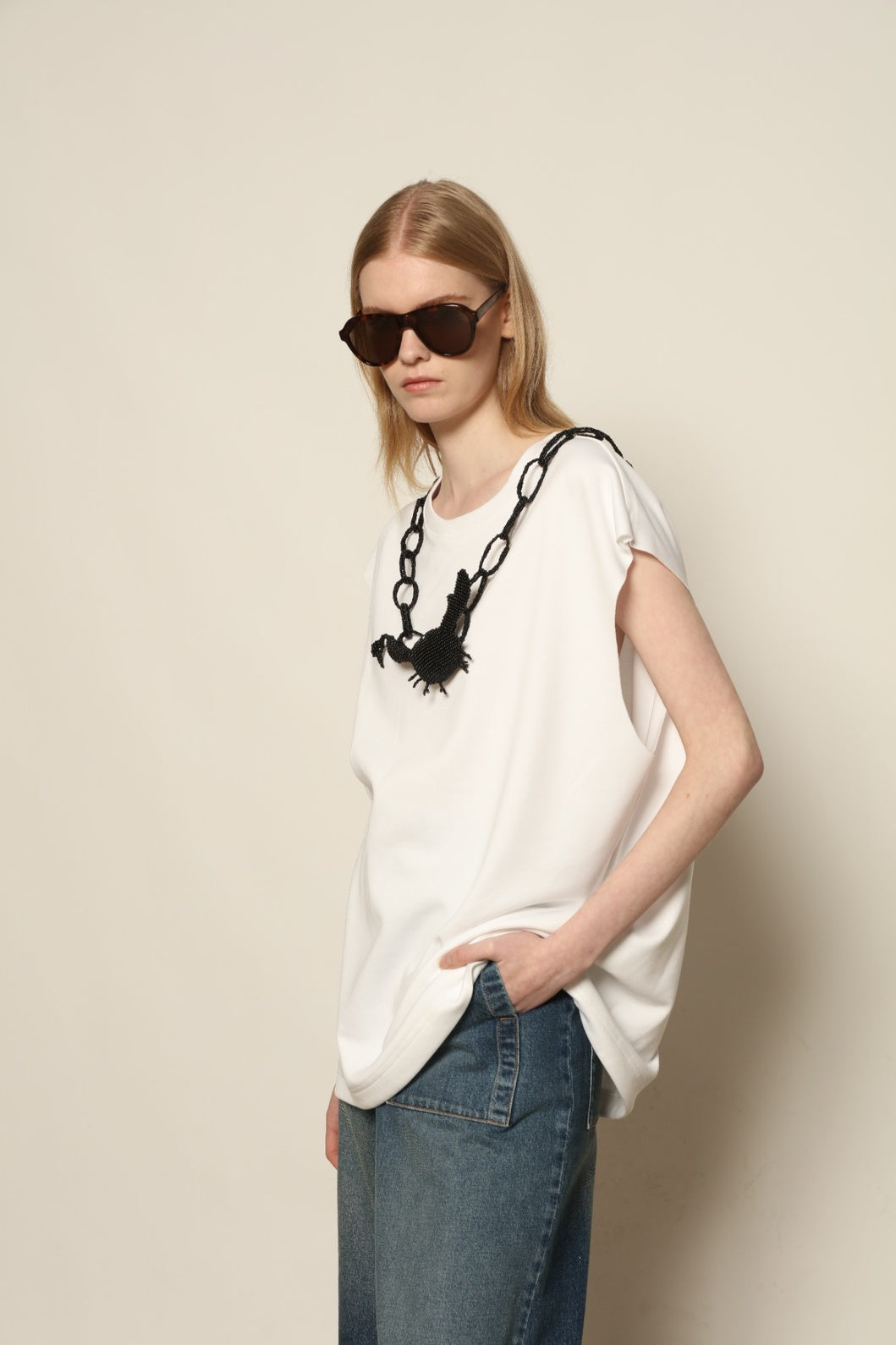 Model is wearing the Tea Cotton Jersey T-Shirt with Black Crab by Maison Jejia, a relaxed cotton tee featuring a playful beaded crab necklace detail, curated in the House of Nomad Stories selection.