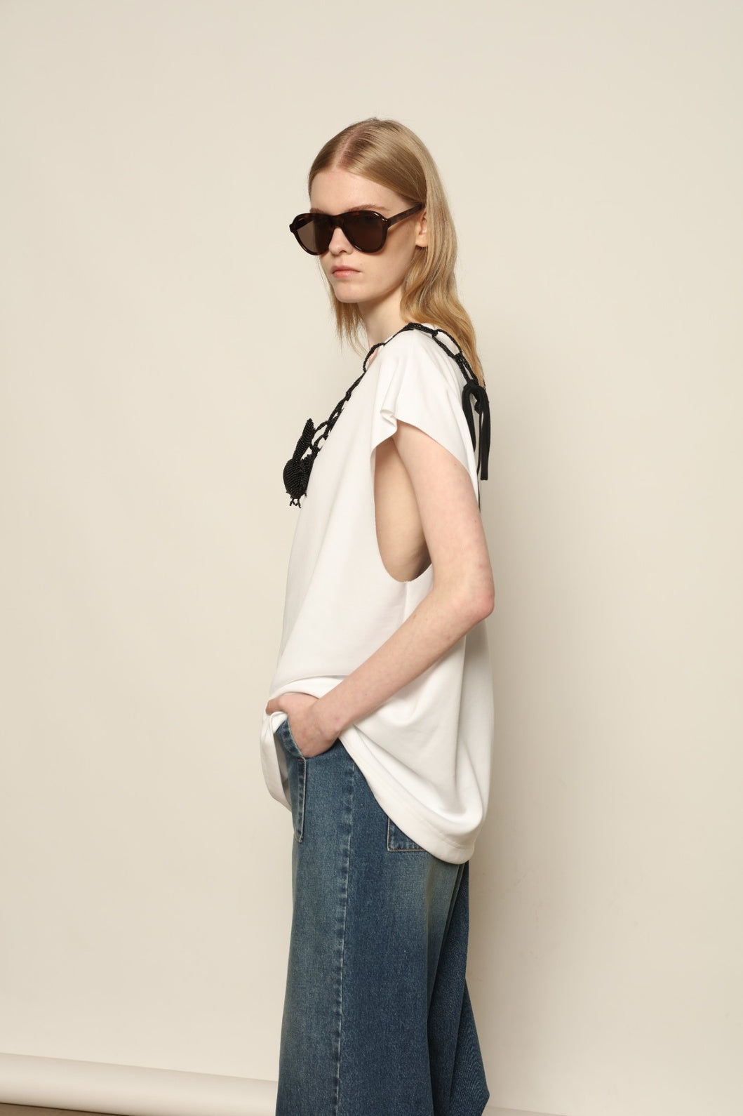 Model is wearing the Tea Cotton Jersey T-Shirt with Black Crab by Maison Jejia, a relaxed cotton tee featuring a playful beaded crab necklace detail, curated in the House of Nomad Stories selection.