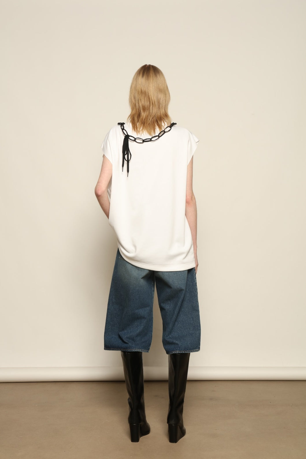 Model is wearing the Tea Cotton Jersey T-Shirt with Black Crab by Maison Jejia, a relaxed cotton tee featuring a playful beaded crab necklace detail, curated in the House of Nomad Stories selection.