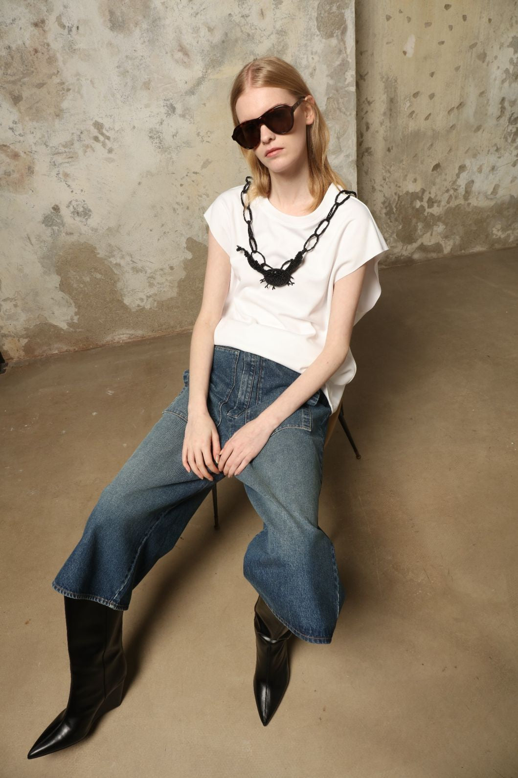Model is wearing the Tea Cotton Jersey T-Shirt with Black Crab by Maison Jejia, a relaxed cotton tee featuring a playful beaded crab necklace detail, curated in the House of Nomad Stories selection.