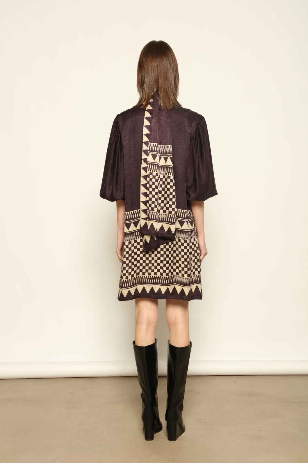Model is wearing the Malaga Short Silk Dress with Belt by House of Nomad Stories, hand-printed in Ajrakh silk with balloon sleeves and a waist belt.