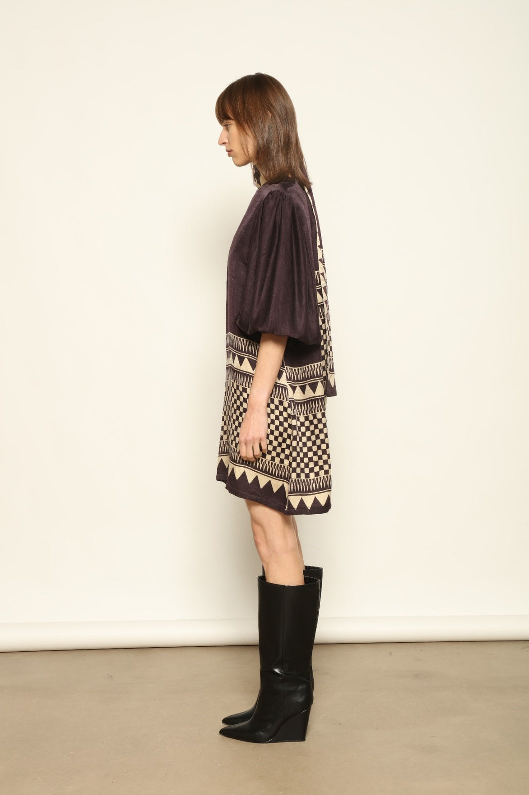 Model is wearing the Malaga Short Silk Dress with Belt by House of Nomad Stories, hand-printed in Ajrakh silk with balloon sleeves and a waist belt.