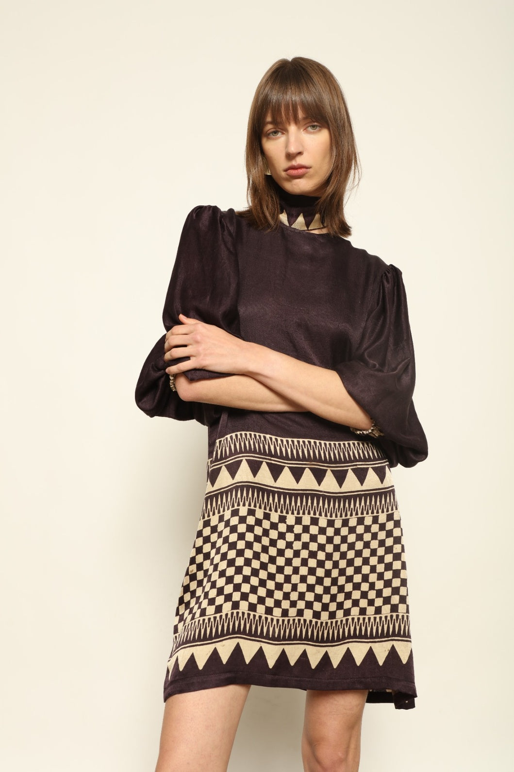 Model is wearing the Malaga Short Silk Dress with Belt by House of Nomad Stories, hand-printed in Ajrakh silk with balloon sleeves and a waist belt.