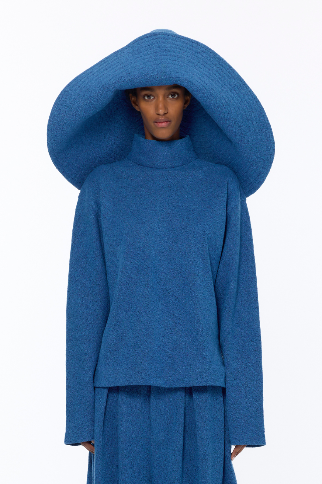 French Blue Bouclé Pamela Hat by Marrakshi Life, crafted in Marrakesh with a wide sculptural brim, soft textured bouclé finish and floral-inspired appliqué detail.