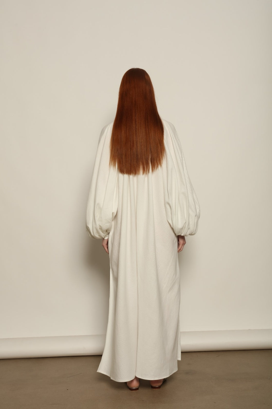 Touareg Dress by Marrakshi Life in crisp handwoven white cotton, featuring a V-neckline, long balloon sleeves with buttoned cuffs, side slits and a removable belt.