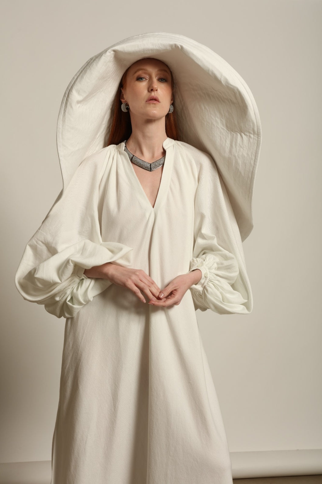 Touareg Dress by Marrakshi Life in crisp handwoven white cotton, featuring a V-neckline, long balloon sleeves with buttoned cuffs, side slits and a removable belt.