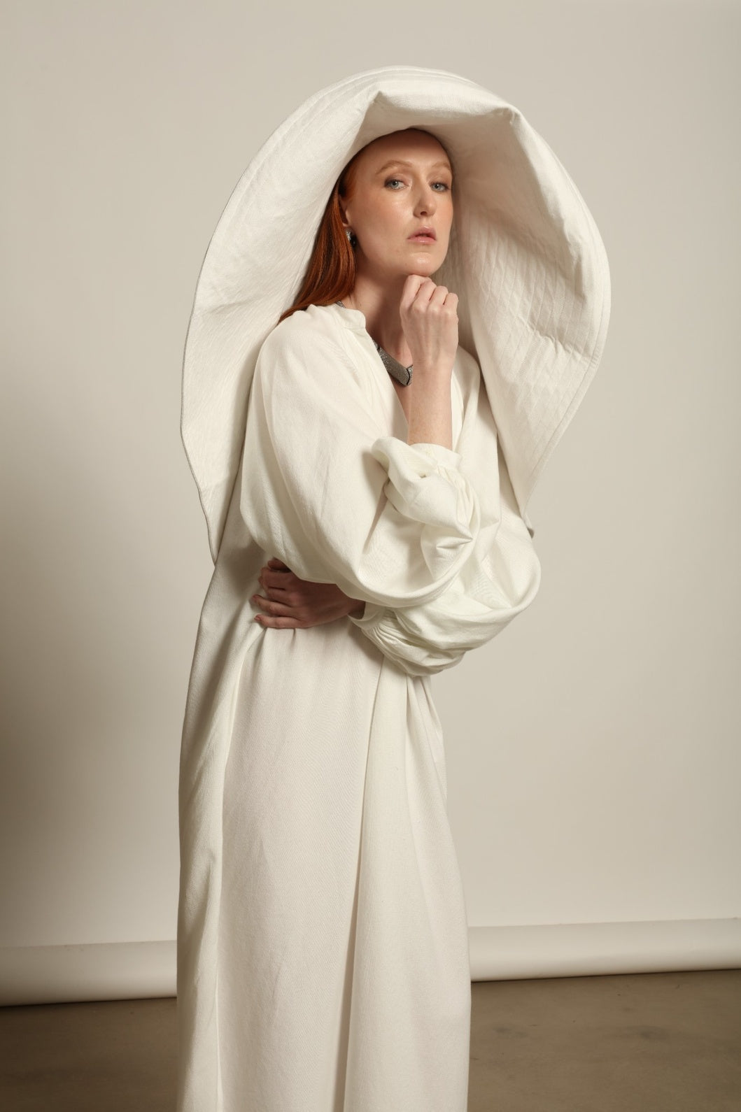 Touareg Dress by Marrakshi Life in crisp handwoven white cotton, featuring a V-neckline, long balloon sleeves with buttoned cuffs, side slits and a removable belt.