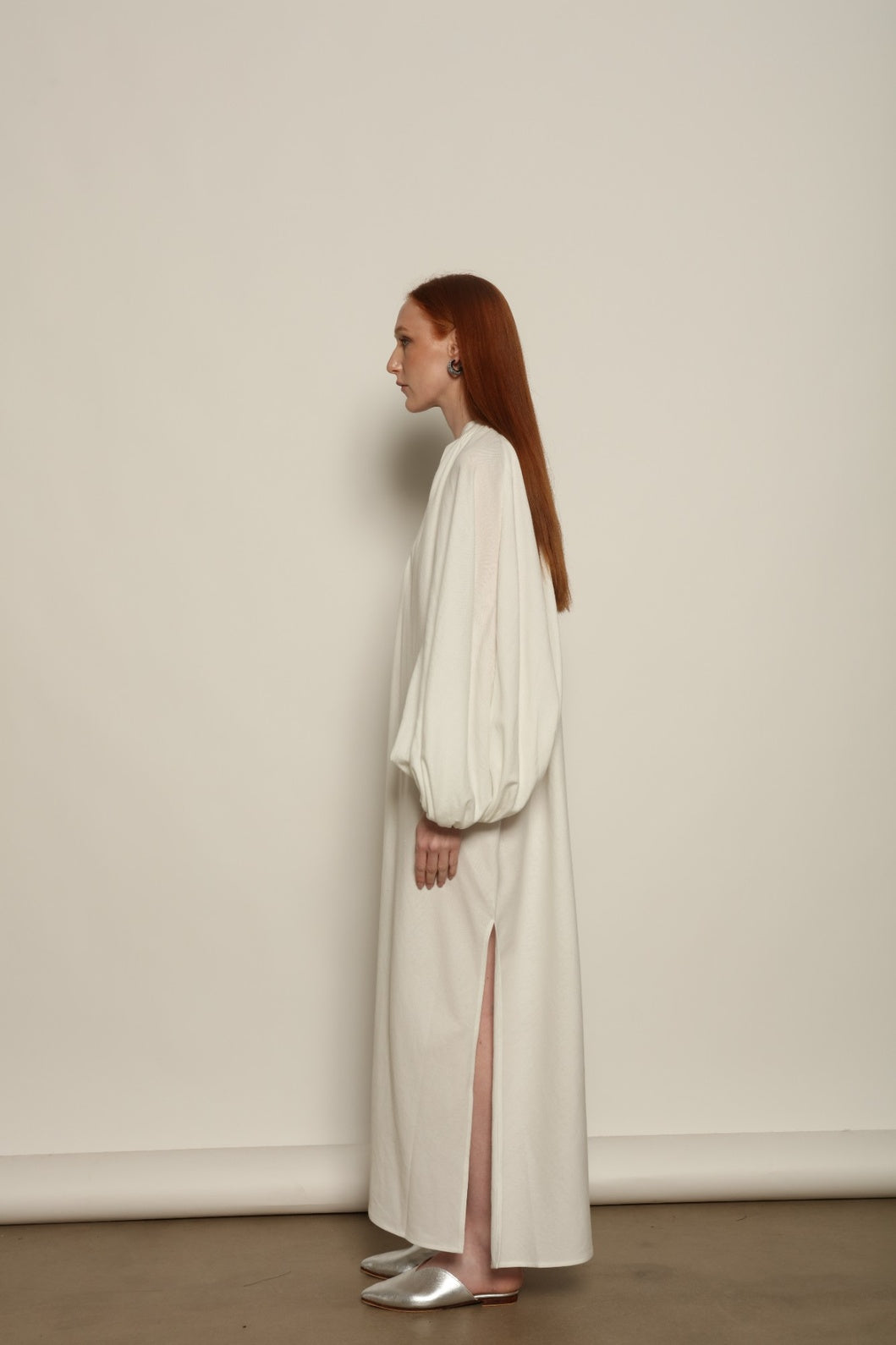 Touareg Dress by Marrakshi Life in crisp handwoven white cotton, featuring a V-neckline, long balloon sleeves with buttoned cuffs, side slits and a removable belt.