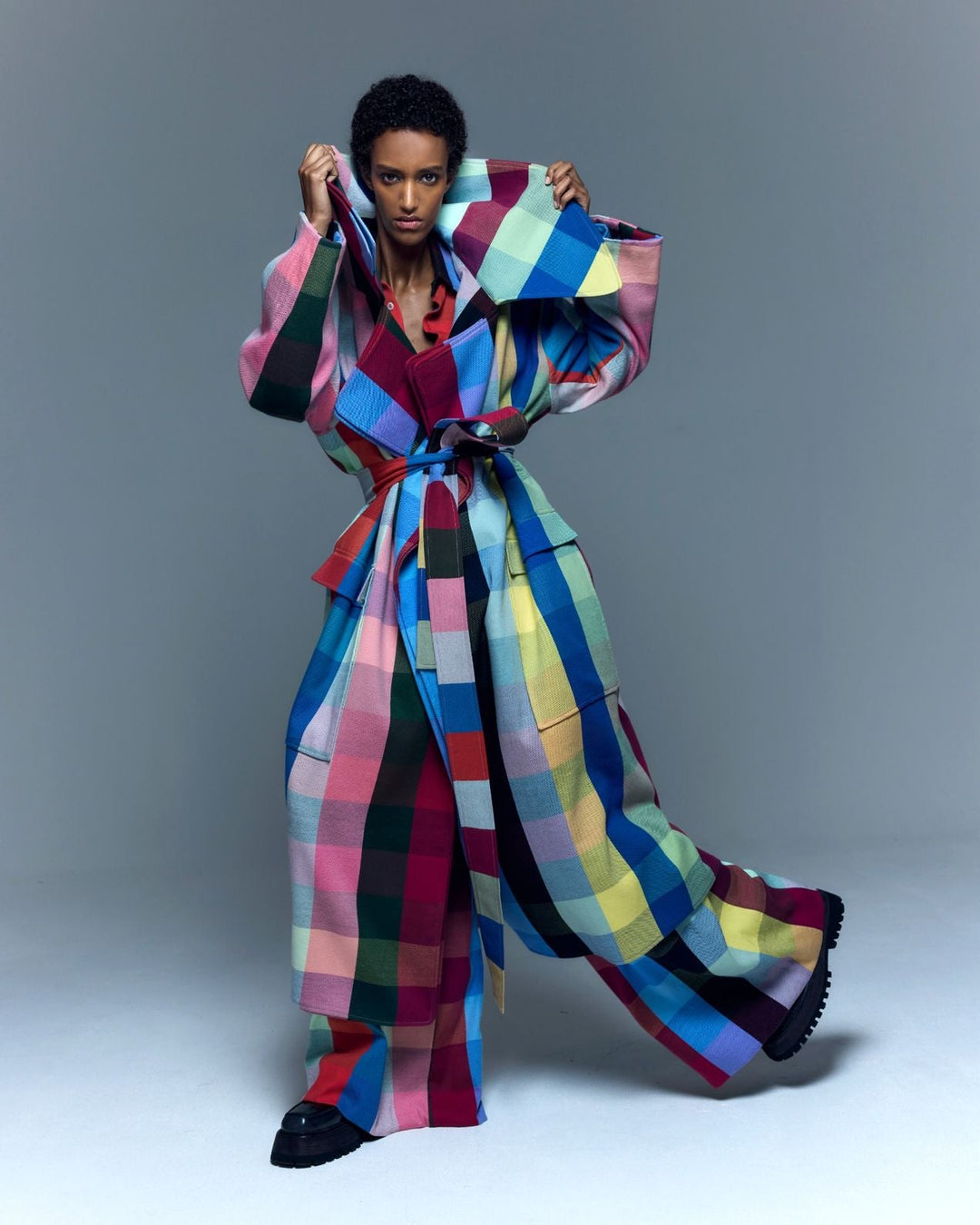 Model is wearing the Double Lapel Overcoat by Marrakshi Life, a hand-woven cotton bouclé coat with oversized plaid, sculptural double lapel and tie belt, curated in the House of Nomad Stories selection.