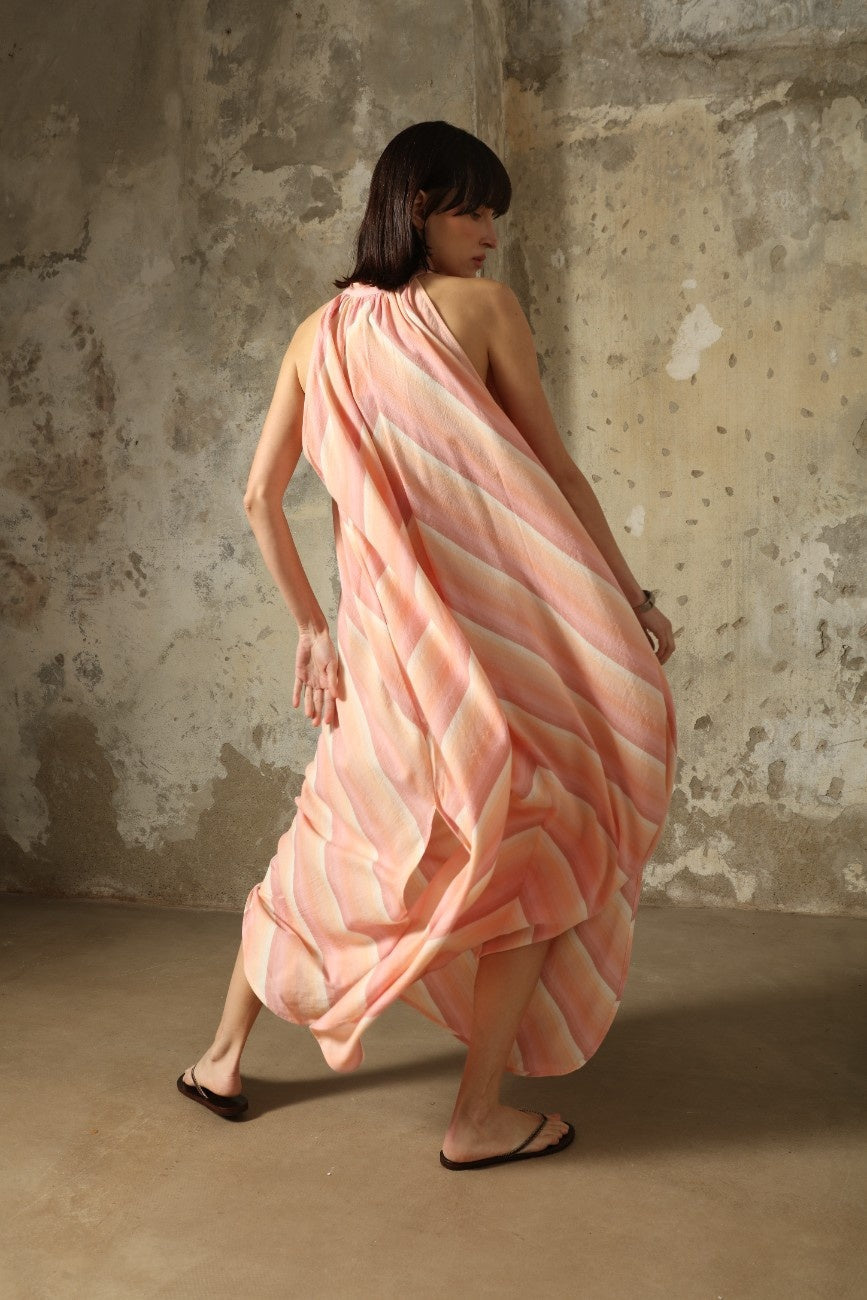 Model is wearing Marrakshi Life halter maxi dress in multicolor striped handwoven cotton, lightweight breathable sleeveless V-neck dress with flowy silhouette and side slits from the curated selection of House of Woven Stories