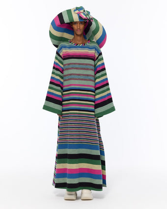 Model is wearing the Kimono Bouclé Multicolor Dress by Marrakshi Life, a hand-woven striped cotton bouclé dress with vibrant colors and flowing kimono sleeves, curated in the House of Nomad Stories selection.