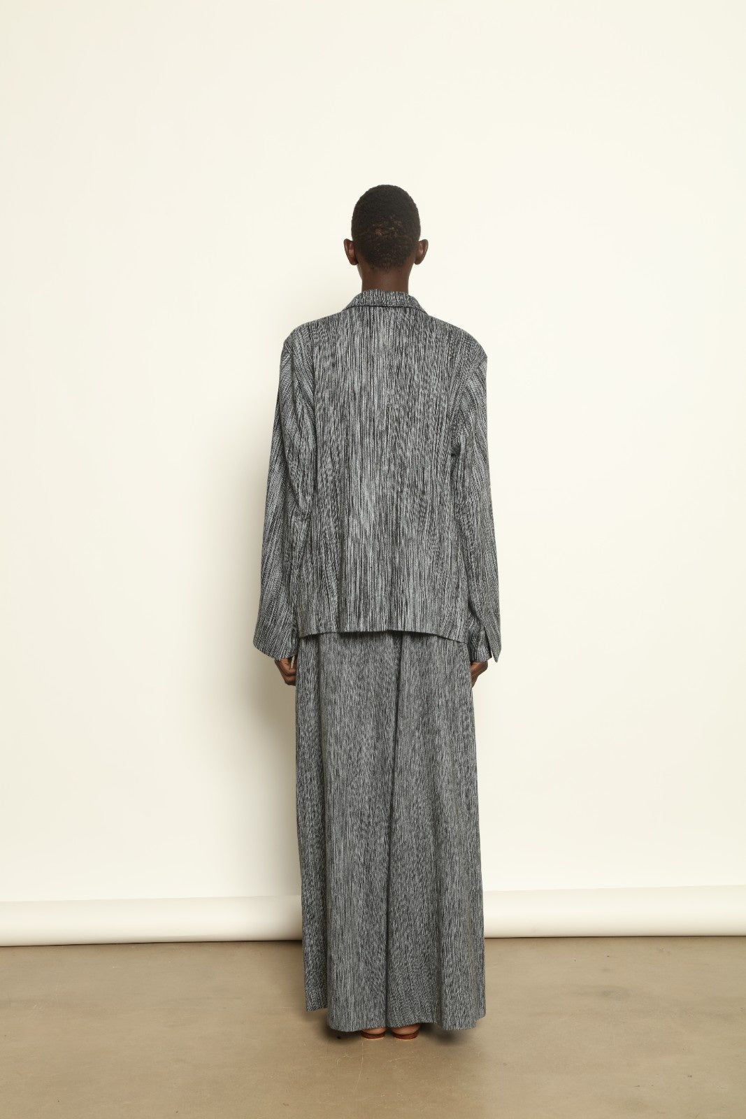 Model is wearing the Mid Rise Grey Chambray Pant by Marrakshi Life, part of House of Nomad Stories collection, handwoven cotton wide-leg pants with relaxed fit and subtle textured chambray