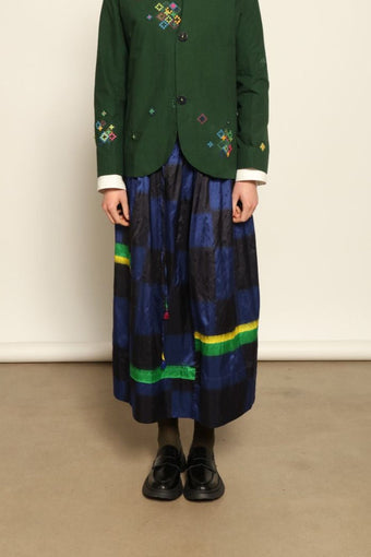 Model is wearing the Miraj 106 Cotton and Silk Skirt by Injiri, handcrafted in India with a blue check base and vibrant green and yellow rectangular motifs, blending heritage craftsmanship with bold contemporary design.