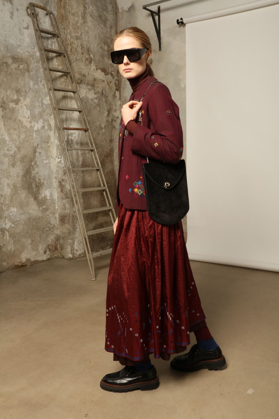 Model wearing the Miraj 195 Jacket by Injiri, handwoven from maroon wool and silk with intricate Jamdani motifs, curated by House of Nomad Stories.