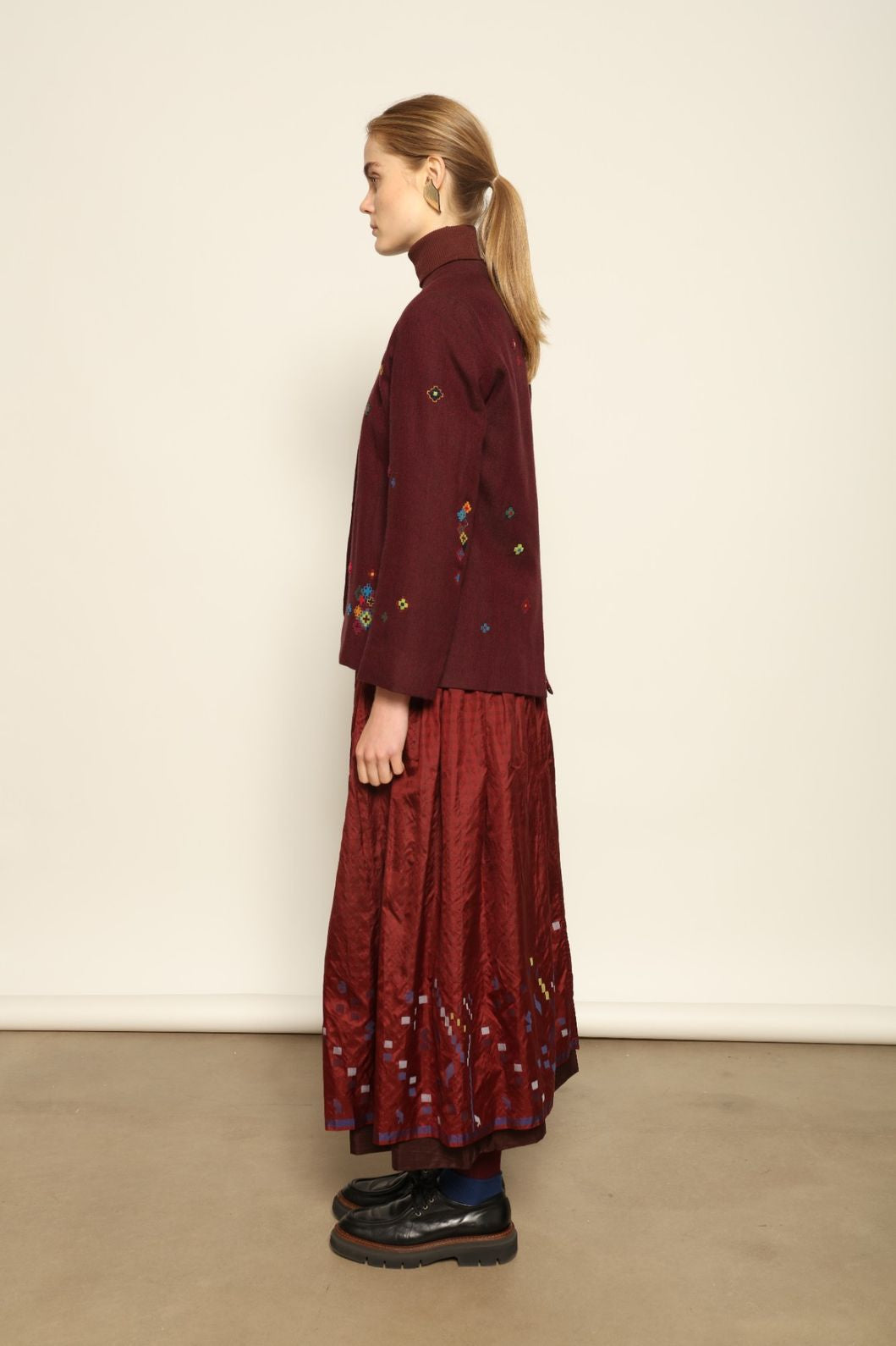 Model wearing the Miraj 195 Jacket by Injiri, handwoven from maroon wool and silk with intricate Jamdani motifs, curated by House of Nomad Stories.
