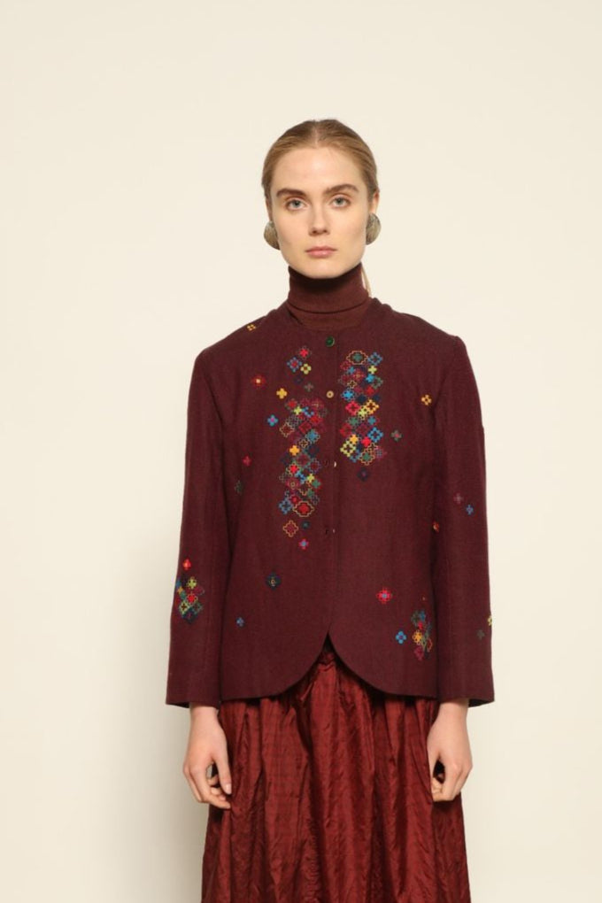 Model wearing the Miraj 195 Jacket by Injiri, handwoven from maroon wool and silk with intricate Jamdani motifs, curated by House of Nomad Stories.