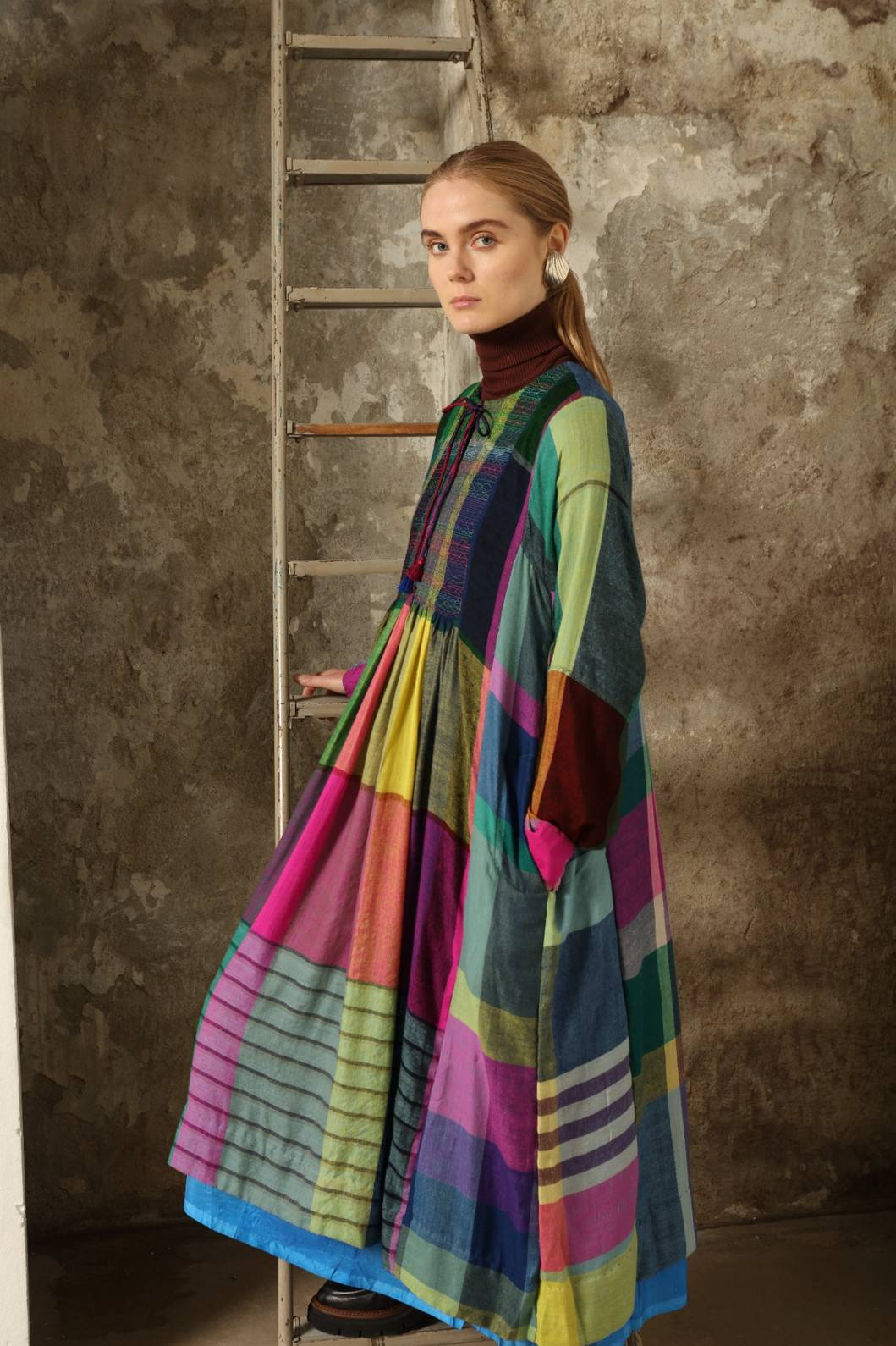Model is wearing the Miraj 55 Pure Cashmere Dress by Injiri, crafted from the finest cashmere with bold multicolor check patterns, blending warmth, artistry, and refined elegance.