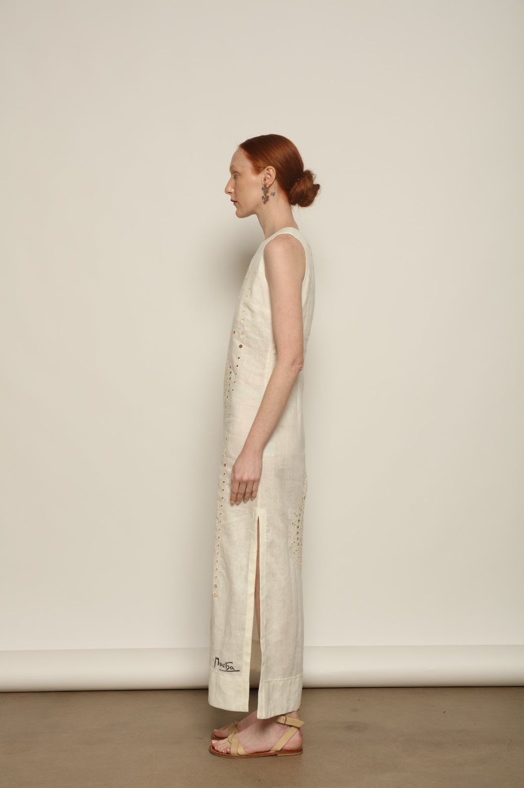 Model is wearing the My Sleeping Gypsy Champenois Dress, an ivory linen dress with hand-cut lace, delicate embroidery, and 24-carat bead accents, from the House of Nomad Stories selection.