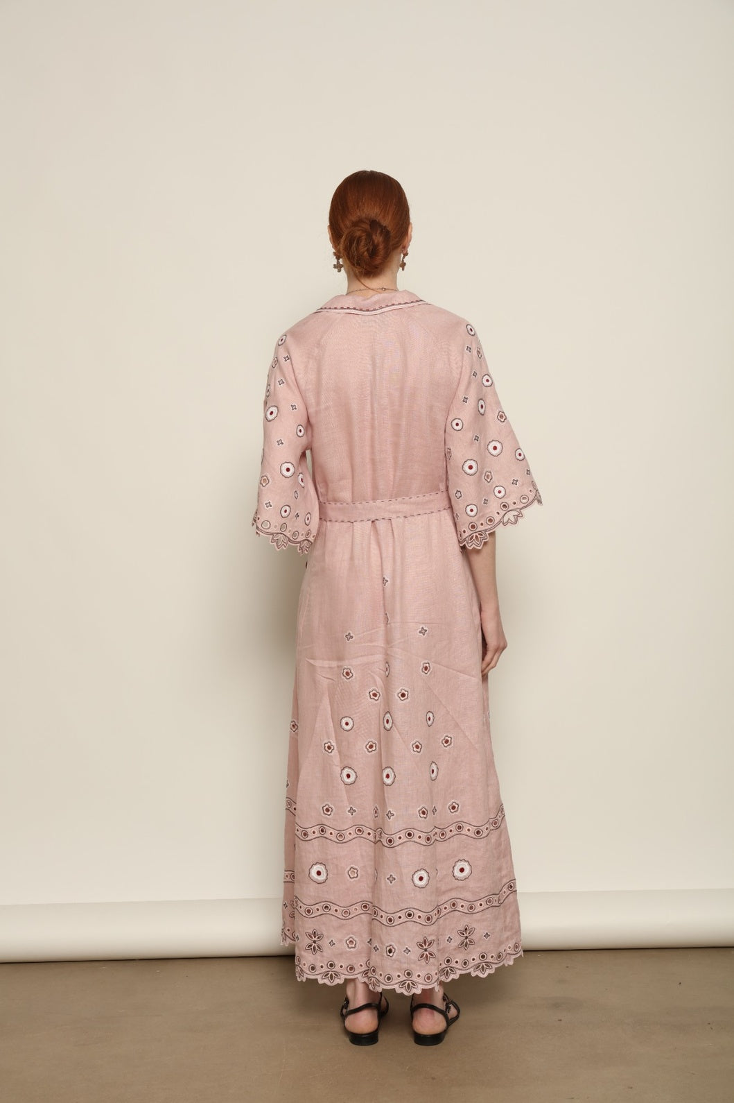 Model is wearing the My Sleeping Gypsy Glass House Long Dress in powder pink linen with Zbiranka pleating, Richelieu embroidery, and 24-carat bead accents, from the House of Nomad Stories selection.