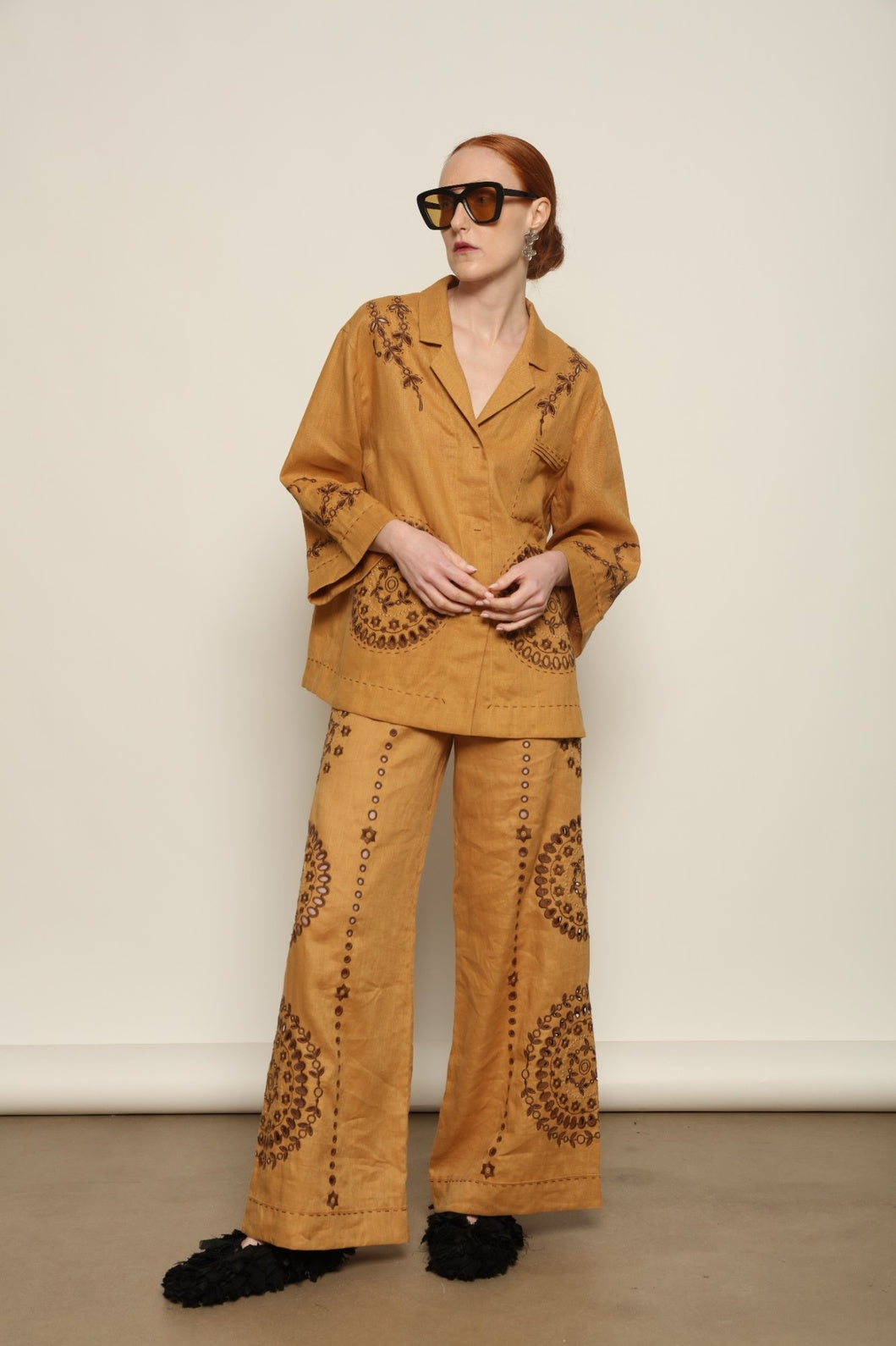 Model is wearing the My Sleeping Gypsy Sarah Jacket, an ivory linen jacket with hand-cut lace, intricate embroidery, and 24-carat bead accents, from the House of Nomad Stories selection.