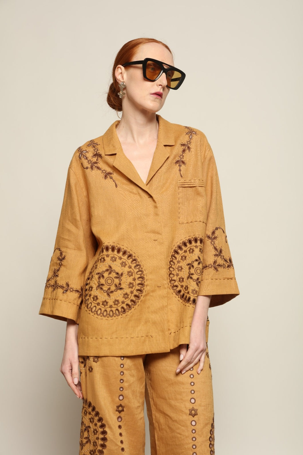 Model is wearing the My Sleeping Gypsy Sarah Jacket, an ivory linen jacket with hand-cut lace, intricate embroidery, and 24-carat bead accents, from the House of Nomad Stories selection.