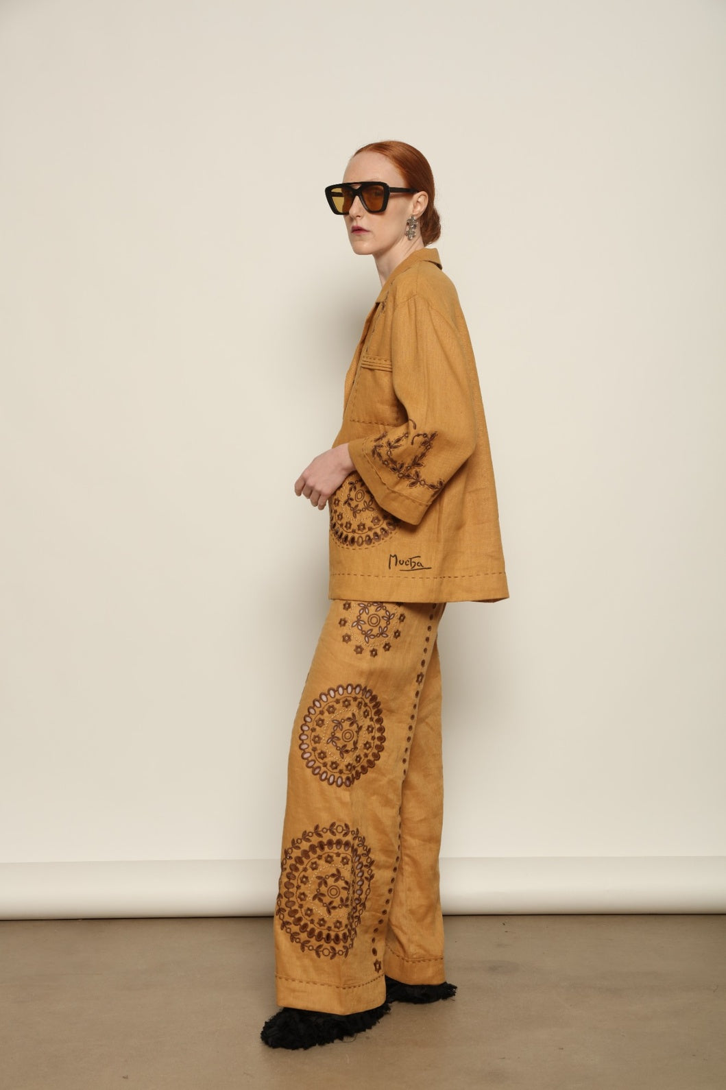Model is wearing the My Sleeping Gypsy Sarah Pants, high-waisted 100% linen trousers with handmade lace, tonal embroidery, and 24-carat bead accents, from the House of Nomad Stories selection.