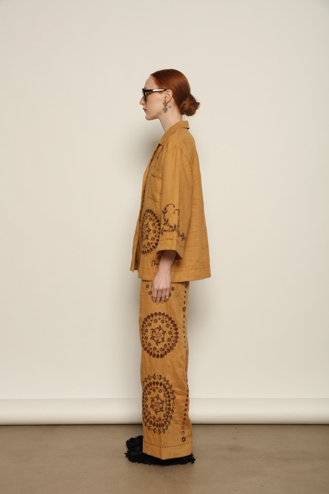 Model is wearing the My Sleeping Gypsy Sarah Pants, high-waisted 100% linen trousers with handmade lace, tonal embroidery, and 24-carat bead accents, from the House of Nomad Stories selection.