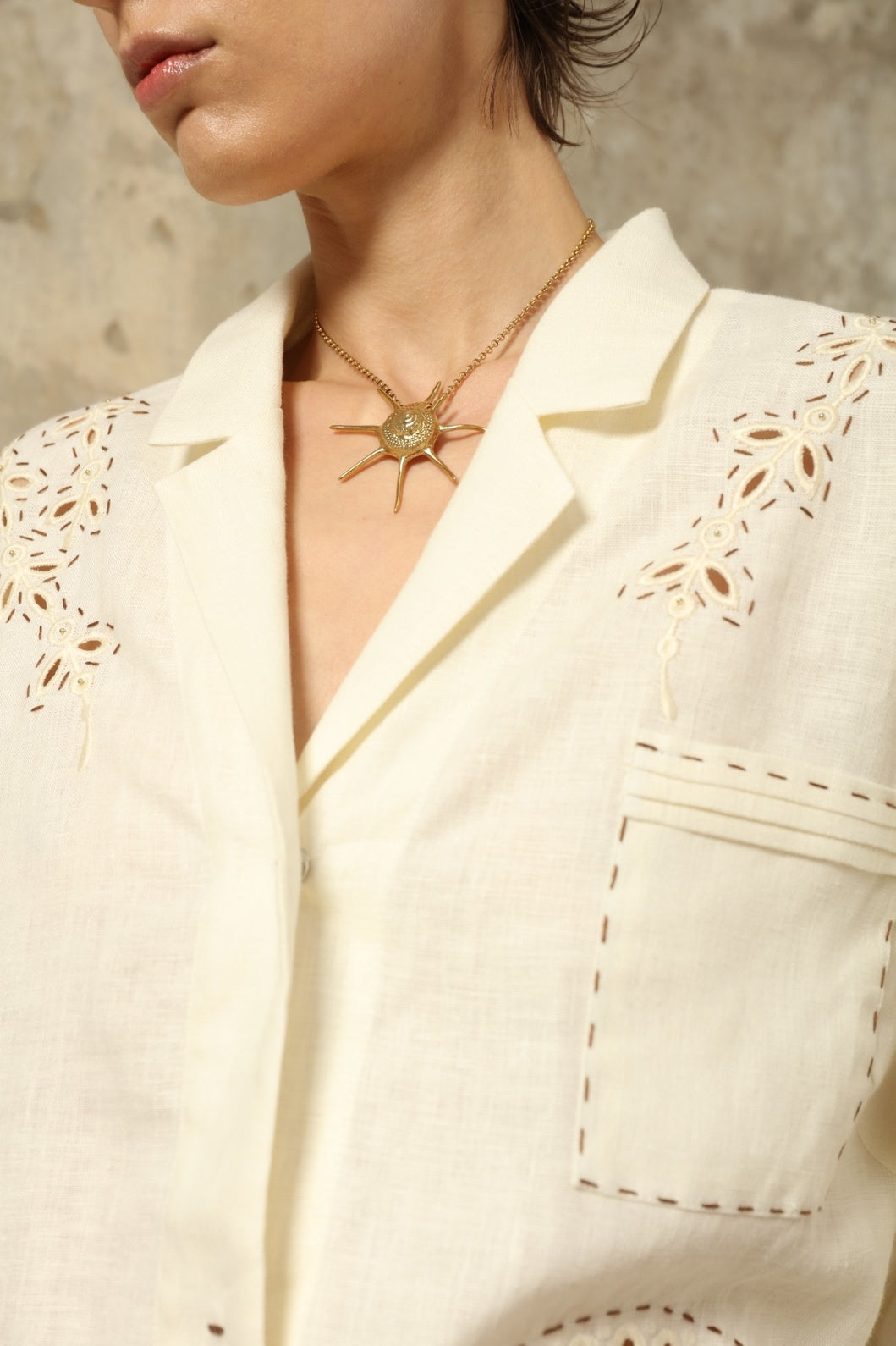 Model is wearing the My Sleeping Gypsy Sarah Suit, a handcrafted ivory linen set with high-waisted shorts, relaxed jacket, intricate embroidery, and 24-carat bead accents, from the House of Nomad Stories selection.