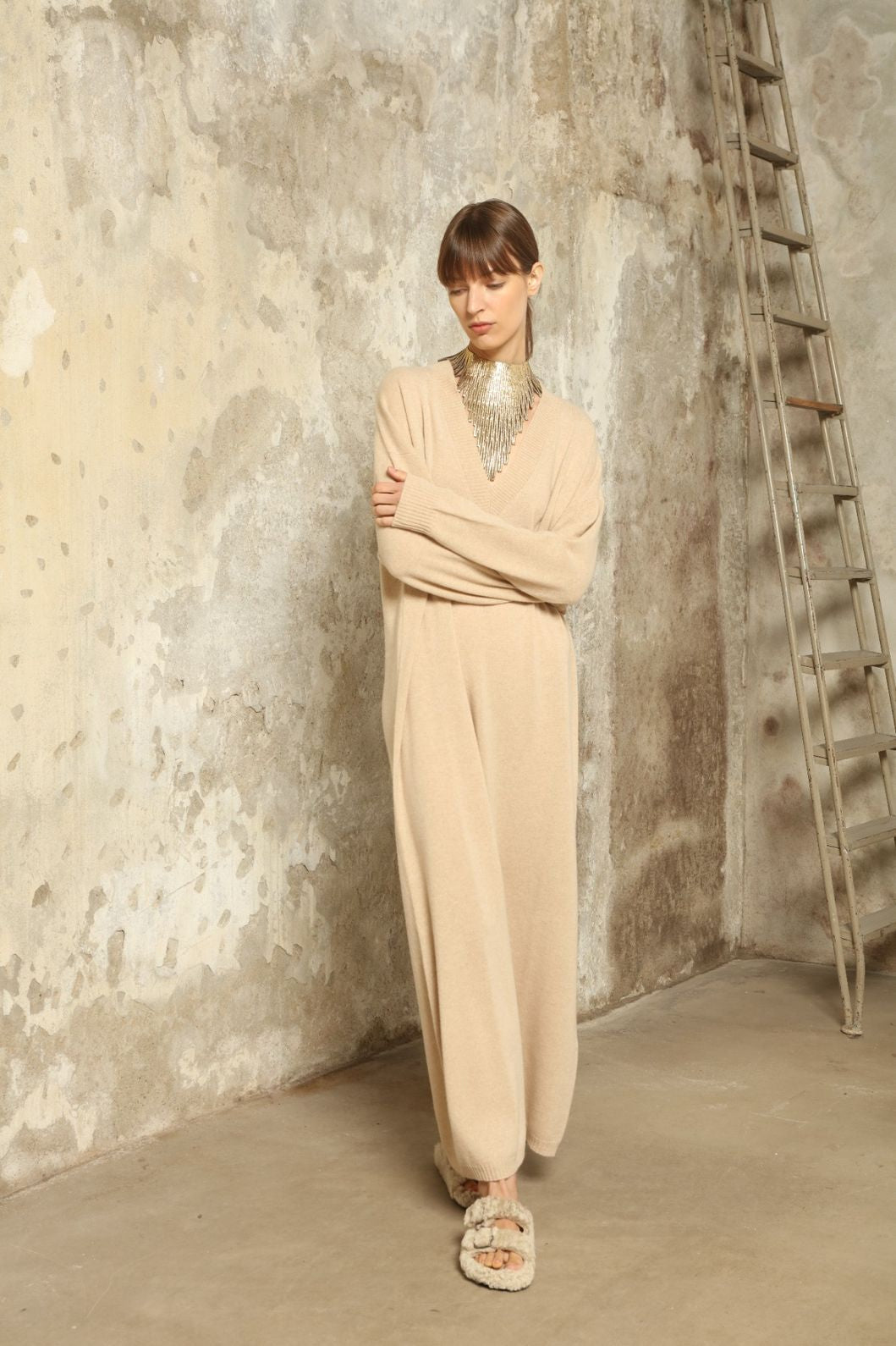 Model is wearing the Natural Katharina V-Neck Cashmere Maxi Dress by House of Nomad Stories, crafted from 100% pure Inner Mongolia cashmere in its uncoloured natural shade, featuring a long flowing silhouette, soft breathable knit, elegant V-neckline, and timeless sustainable luxury design