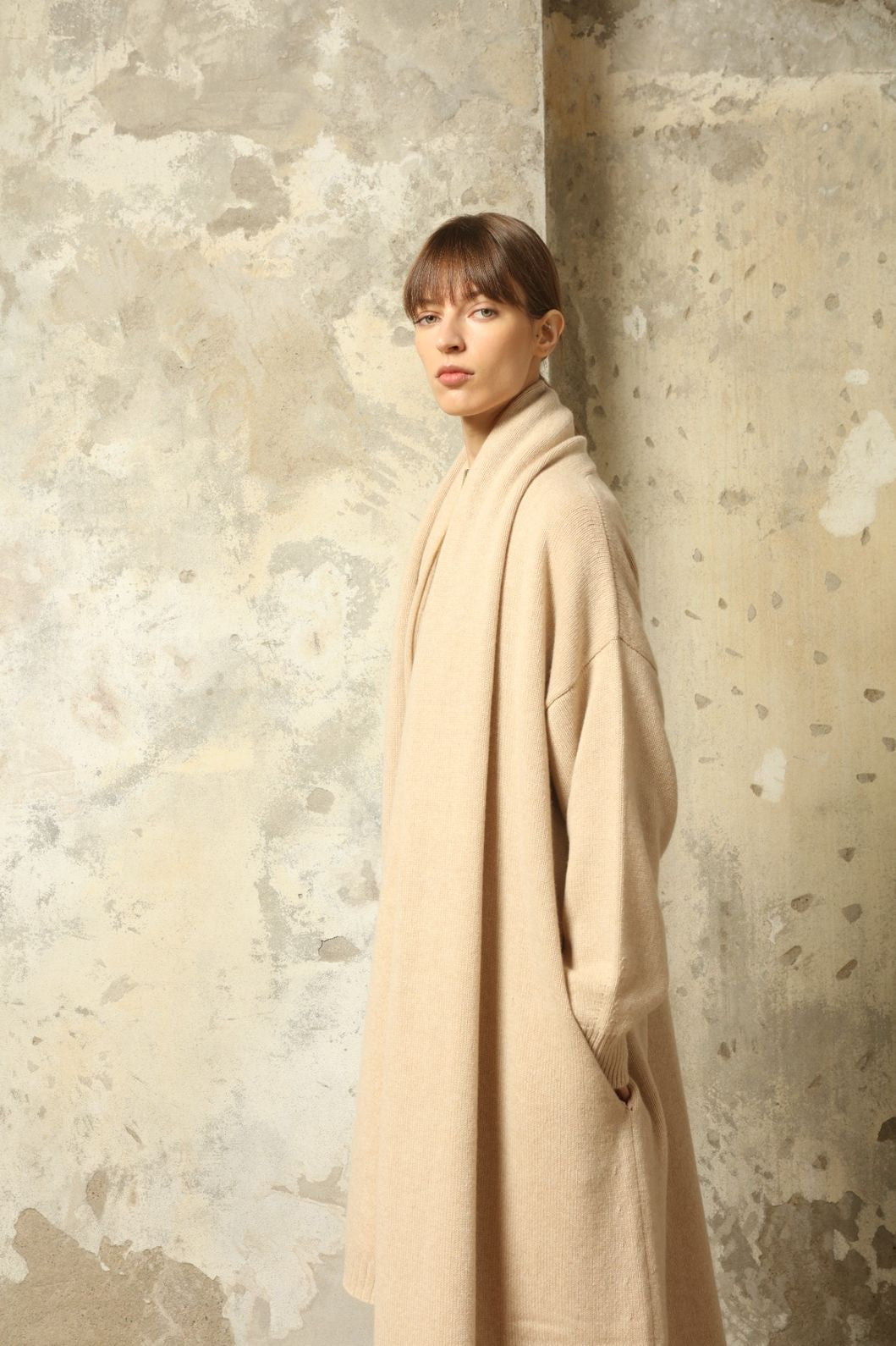 Model wearing the Natural Leni Cashmere Scarf by House of Woven Stories, made from 100% pure Inner Mongolia cashmere, featuring a soft natural shade, lightweight drape, smooth texture, lasting warmth, and ethical sustainable craftsmanship