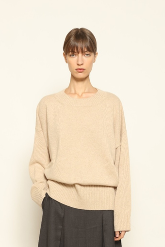 Model is wearing the Natural Nena Round Neck Pure Cashmere Sweater by House of Nomad Stories in a relaxed natural shade, styled in an understated, minimalist look.