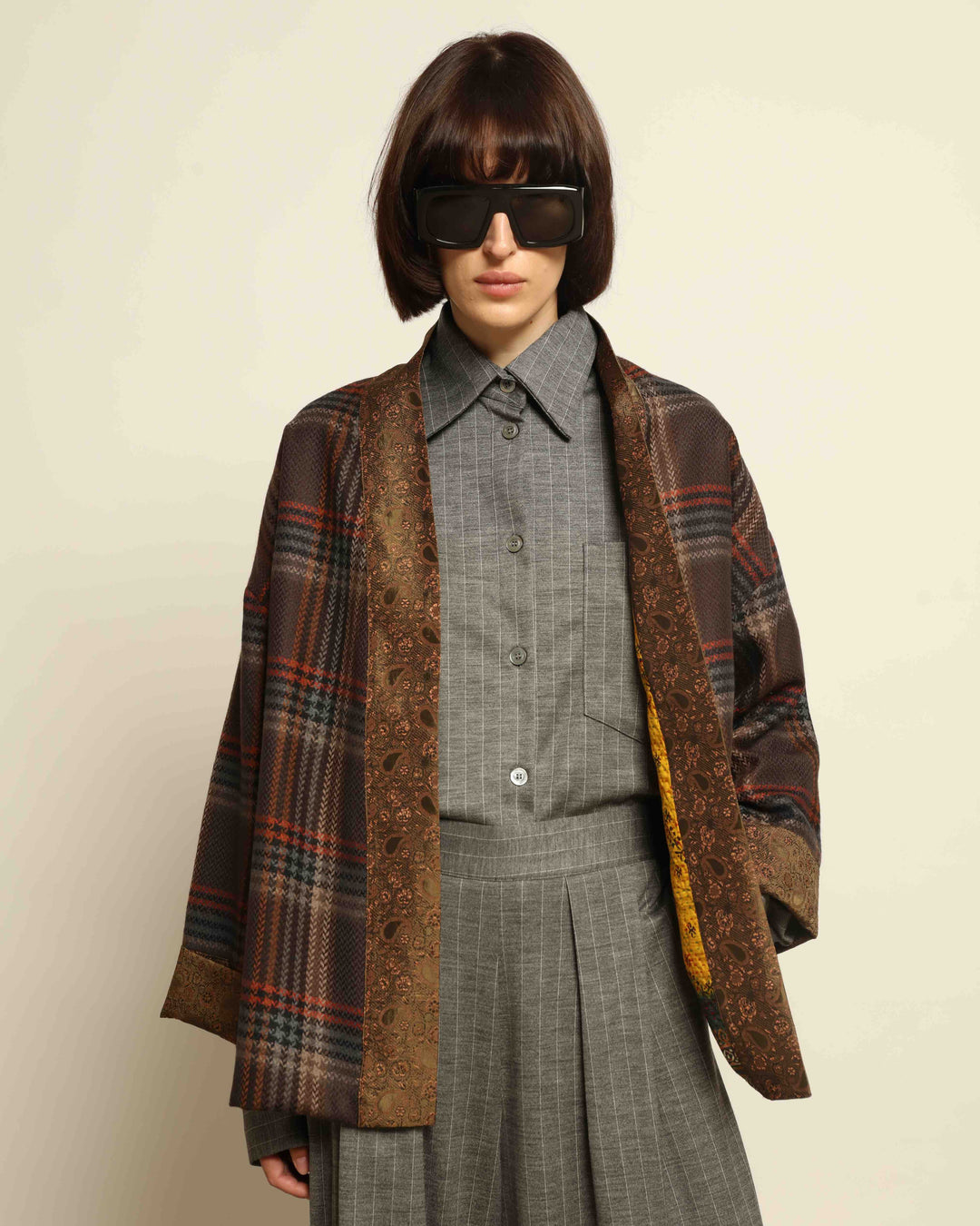 Model is wearing the Obidi Checked Kantha Jacket in wool and silk, with a silk collar and unique printed silk lining, a one-of-a-kind artisanal piece. Part of House of Nomad Stories selection.