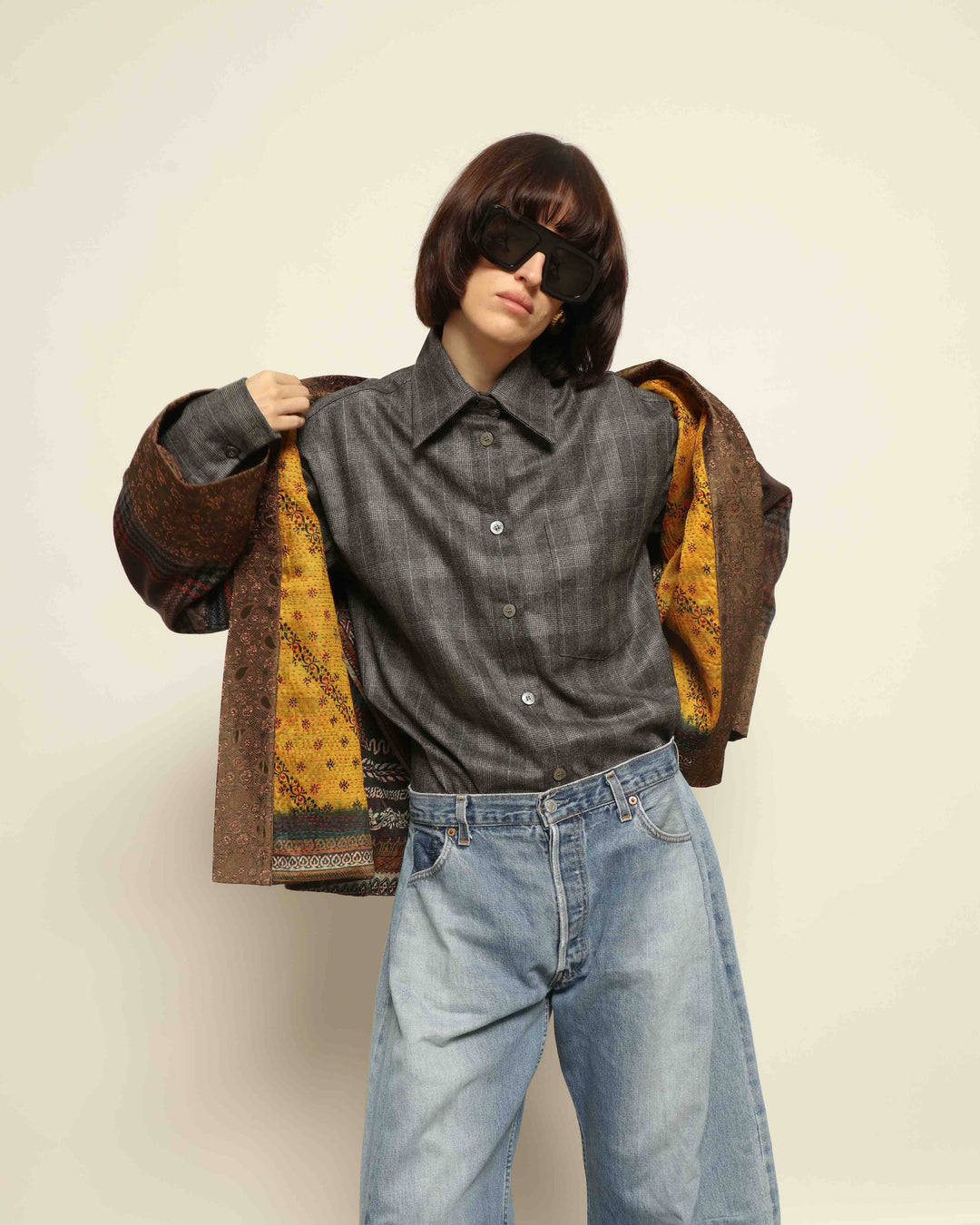 Model is wearing the Obidi Checked Kantha Jacket in wool and silk, with a silk collar and unique printed silk lining, a one-of-a-kind artisanal piece. Part of House of Nomad Stories selection.