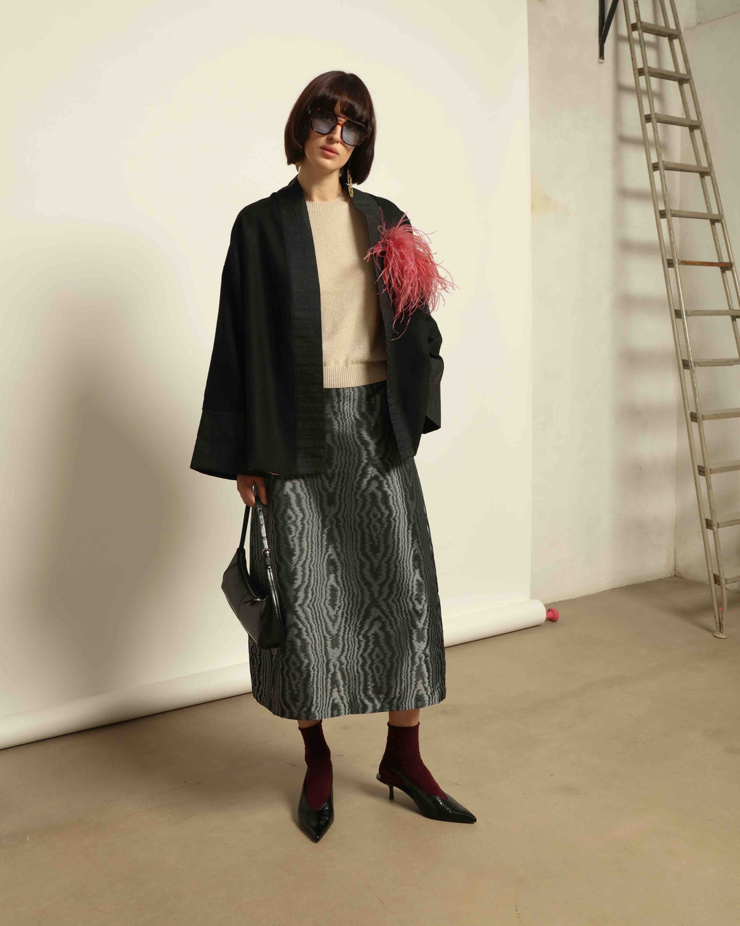 The model is wearing the Obidi Midnight Kantha Jacket in pure black, made of wool with a silk collar and Kantha silk lining, a timeless and versatile piece.
