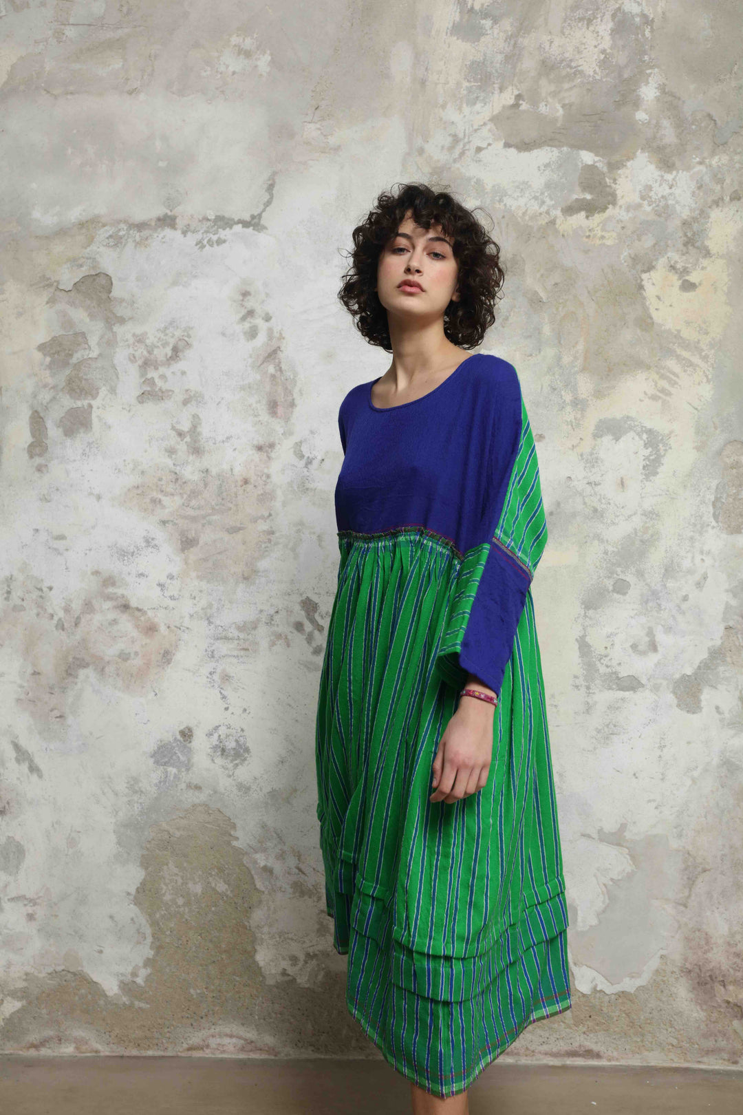 Model wearing the Injiri Wool Midi Dress, handcrafted in India in rich indigo and green tones with a contemporary striped detail, curated by House of Nomad Stories.