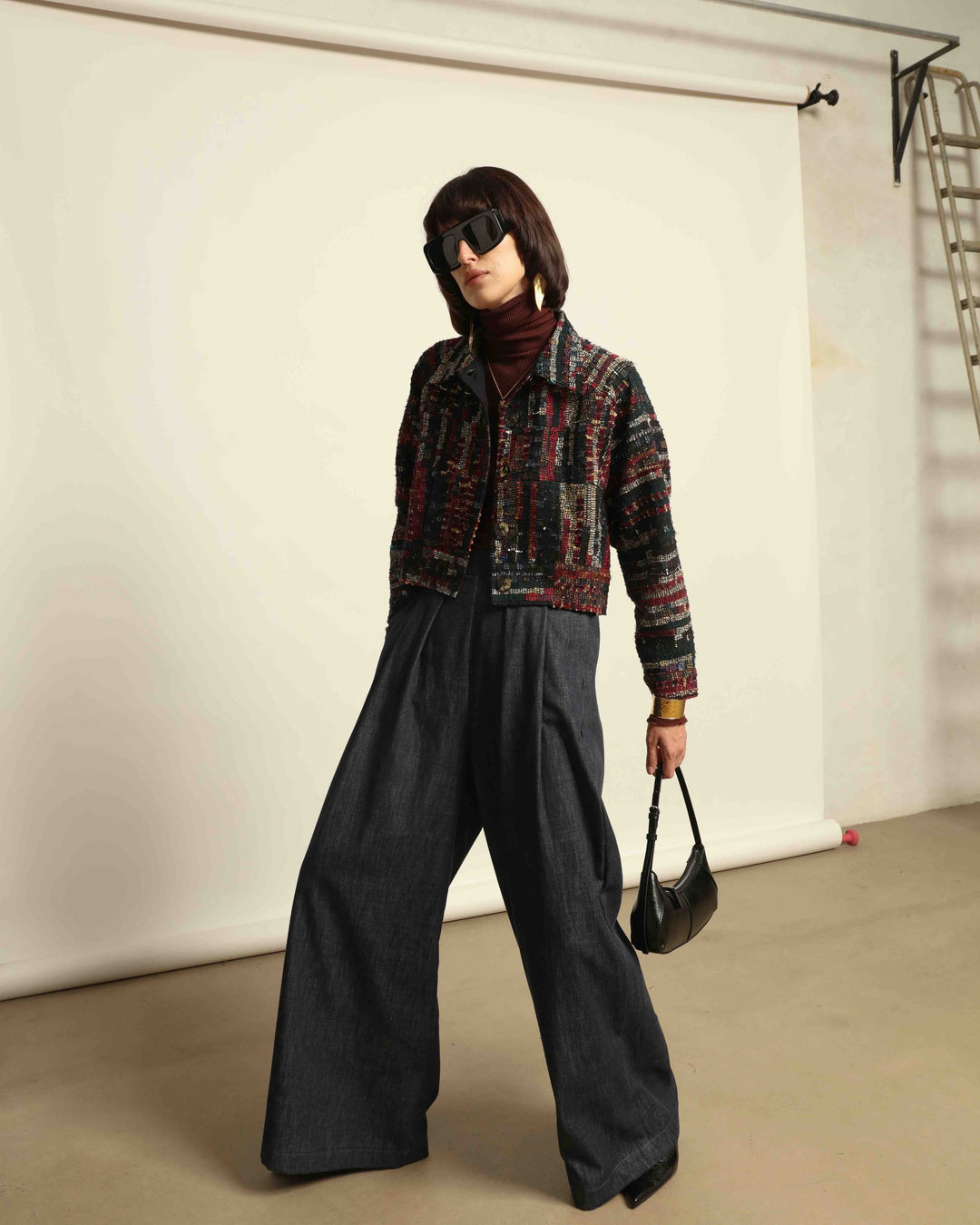 Model is wearing the Rewoven Hand-loomed Bomber by Paiwand, an upcycled unisex jacket crafted from handwoven organic cotton off-cuts with unique color and design variations.