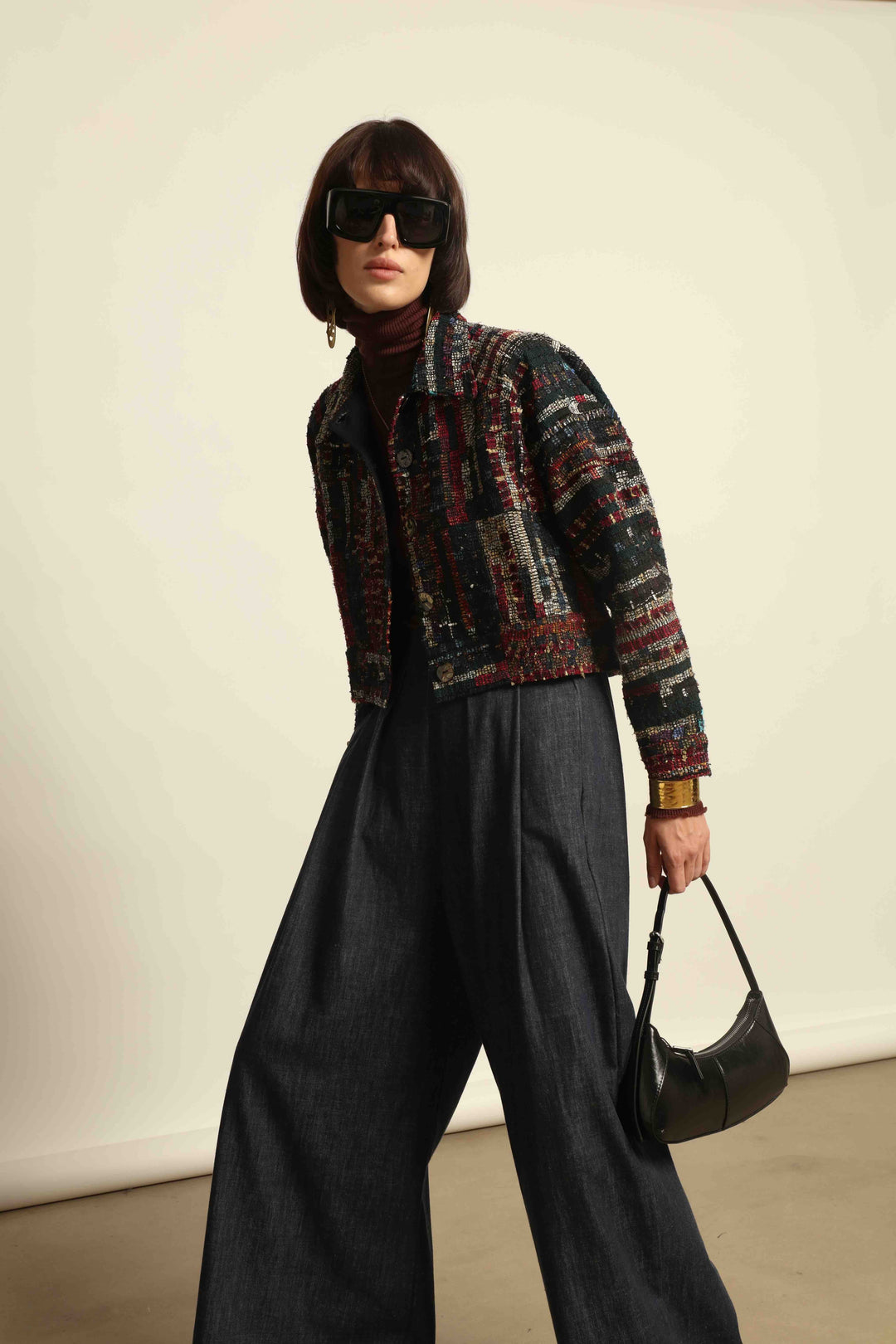 Model is wearing the Rewoven Hand-loomed Bomber by Paiwand, an upcycled unisex jacket crafted from handwoven organic cotton off-cuts with unique color and design variations.