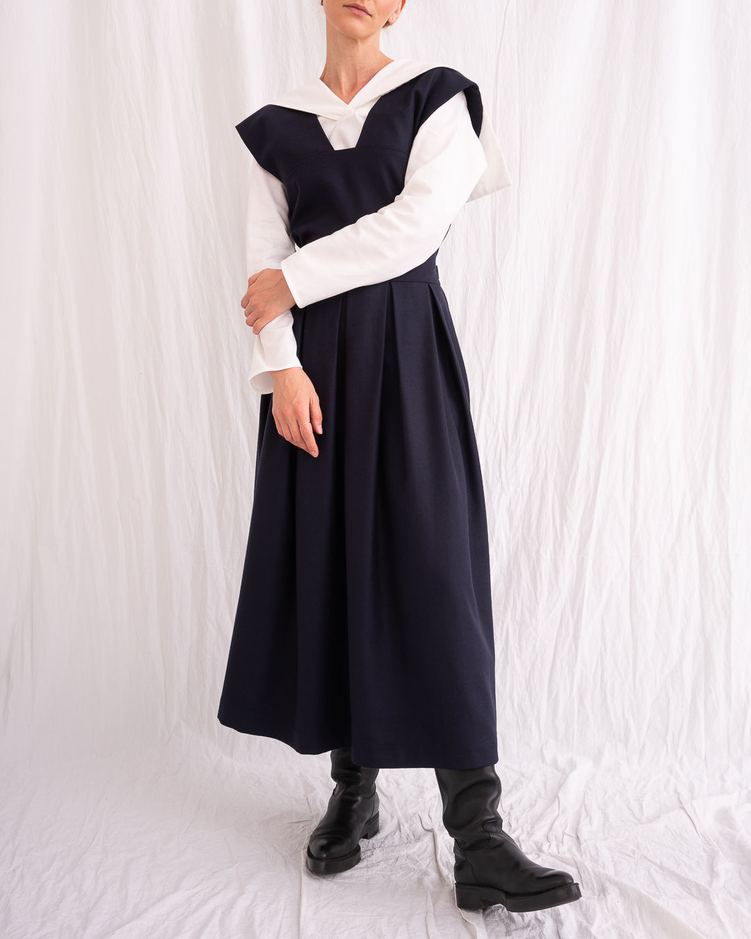 Model is wearing the Sarafan Pure New Wool Dress by Les Vacances d’Irina, a handmade navy merino wool dress with A-line silhouette, tie-back detail, horn buttons, and side pockets, available at House of Nomad Stories.