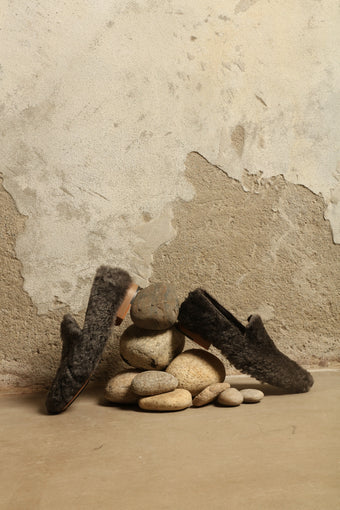 Model is wearing the Grey Wool Baboush Sharwit by House of Nomad Stories, handmade in Marrakesh from soft shearling sheep leather with a cushioned insole and durable rubber sole.