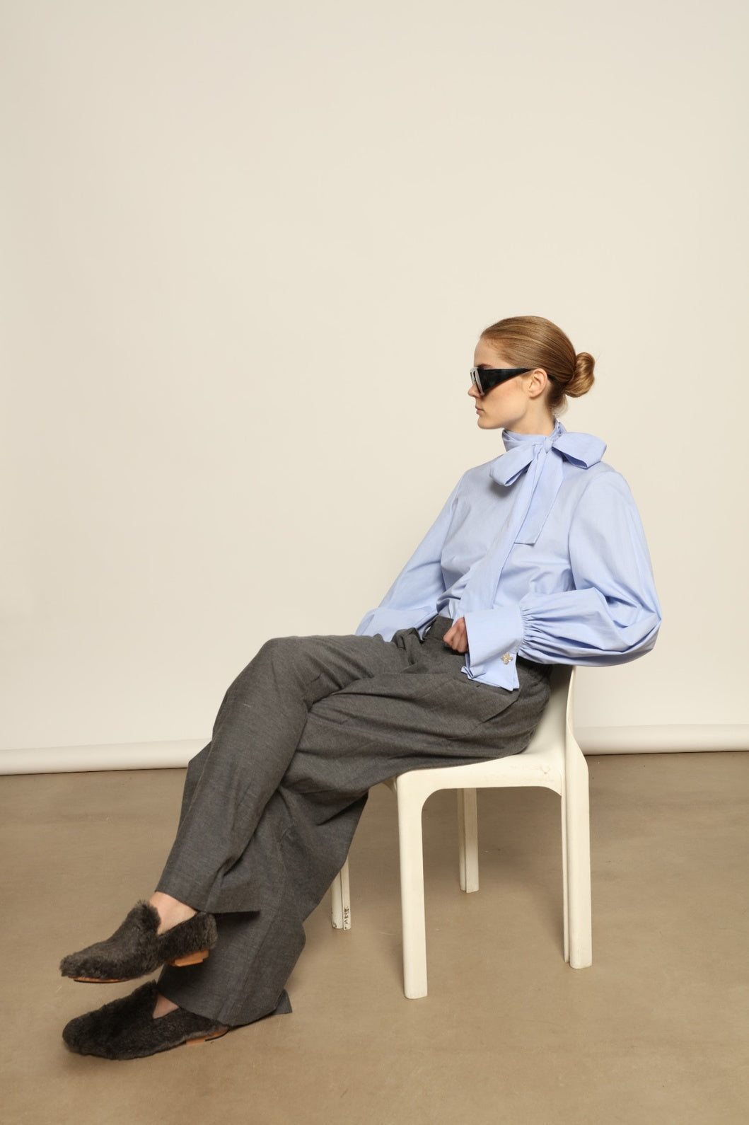 Model is wearing the Grey Wool Baboush Sharwit by House of Nomad Stories, handmade in Marrakesh from soft shearling sheep leather with a cushioned insole and durable rubber sole.