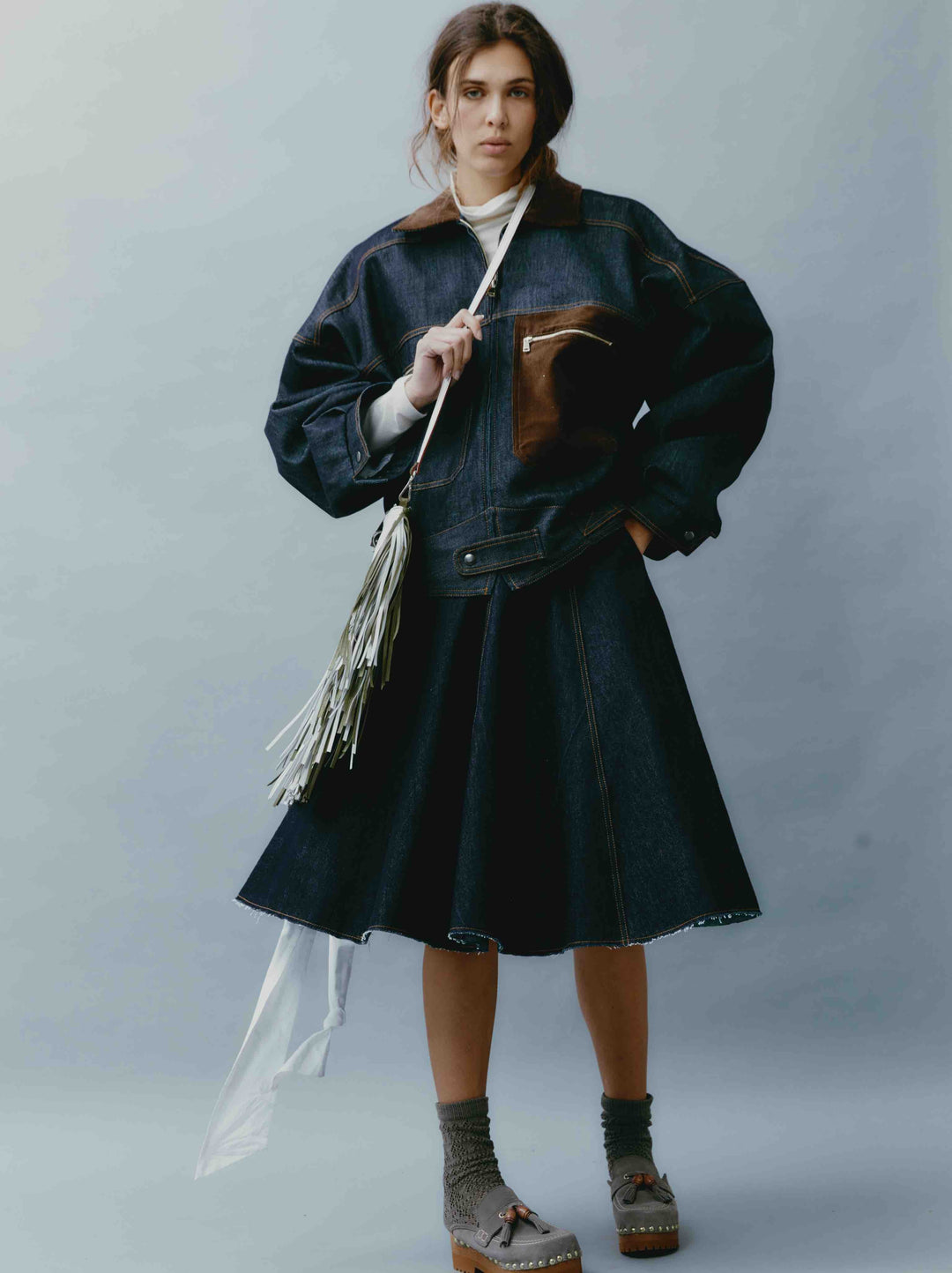 Model is wearing the Sissi Short Blue Jeans Skirt by Maison Jejia, part of the House of Nomad Stories selection, featuring dark blue denim, a structured fit, subtle edgy details, and a polished silhouette.
