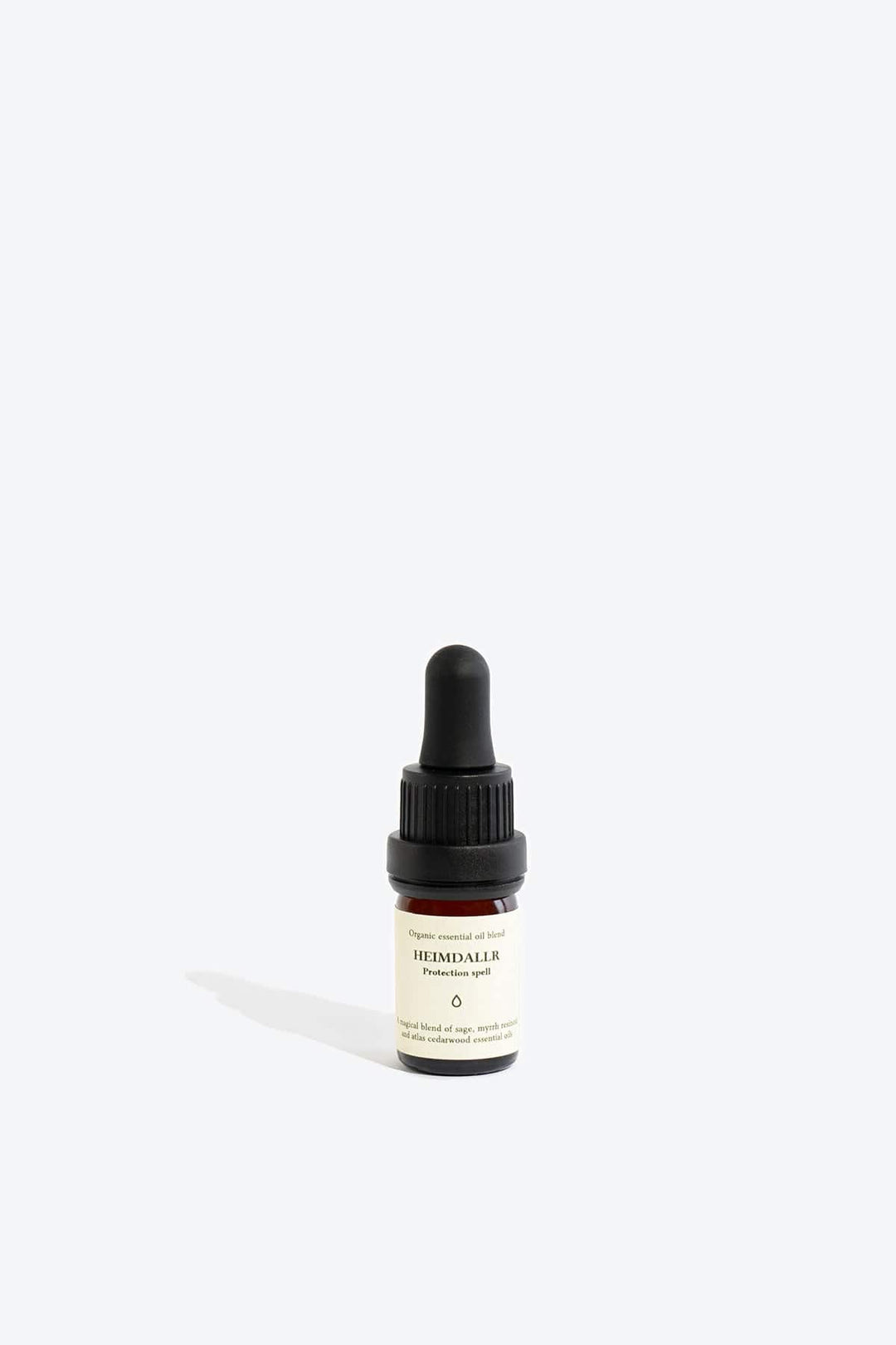 Organic essential oil blend Heimdallr by Smells Like Spells in a glass bottle with dropper, designed for protection and home energy cleansing.