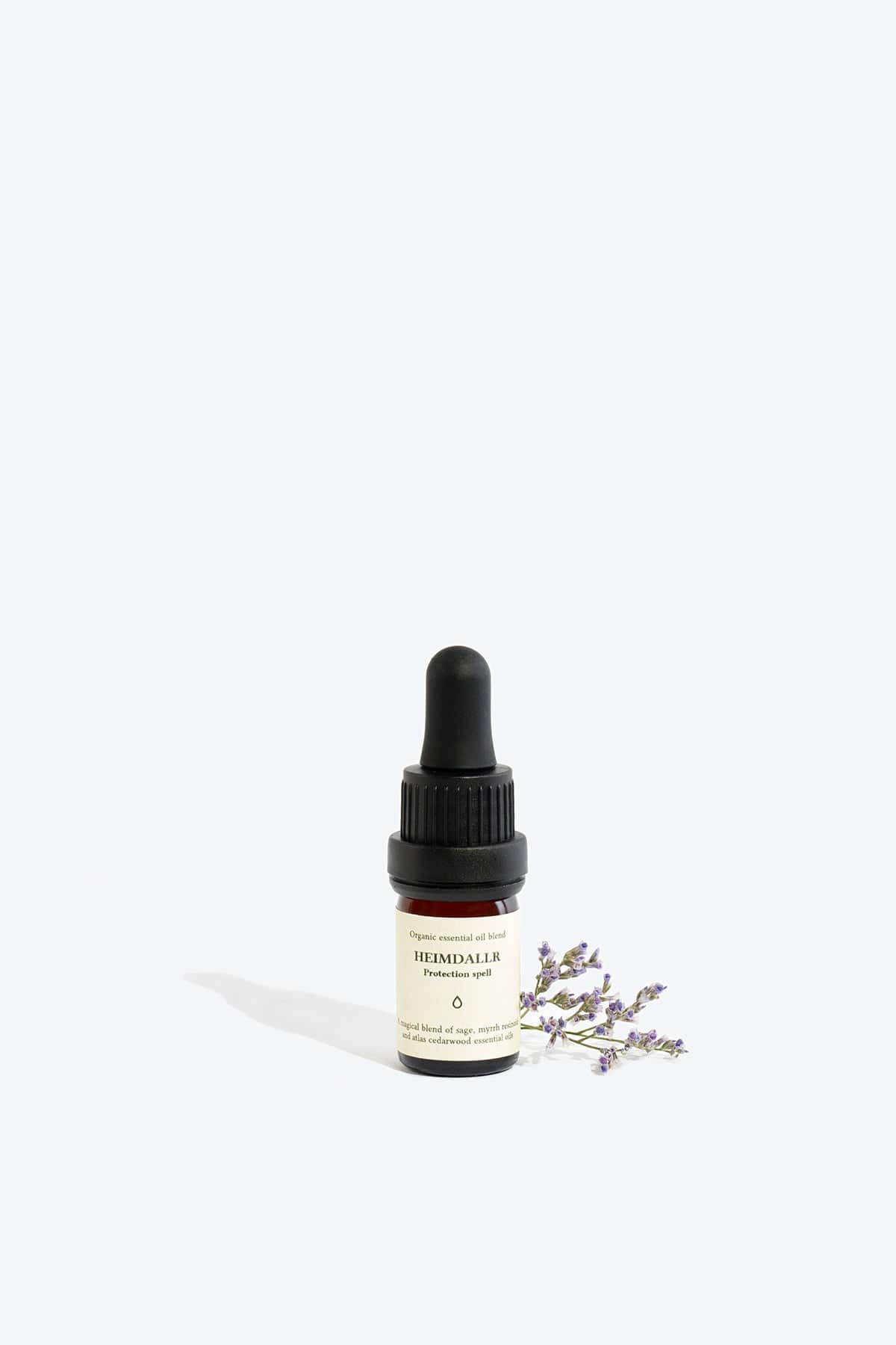 Organic essential oil blend Heimdallr by Smells Like Spells in a glass bottle with dropper, designed for protection and home energy cleansing, offered by House of Nomad Stories.