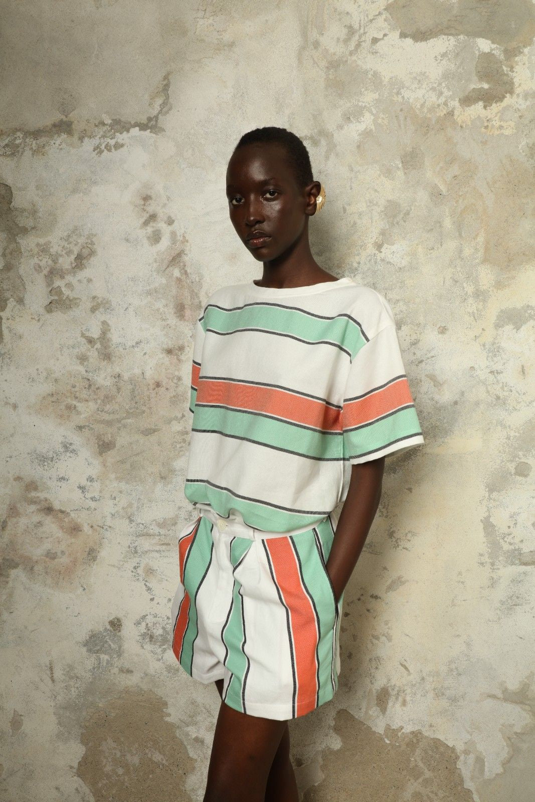Model is wearing The Pleated Short by Marrakshi Life, part of House of Nomad Stories collection, handwoven artisanal cotton shorts with deep front pleats, high waist, and relaxed sculptural silhouette
