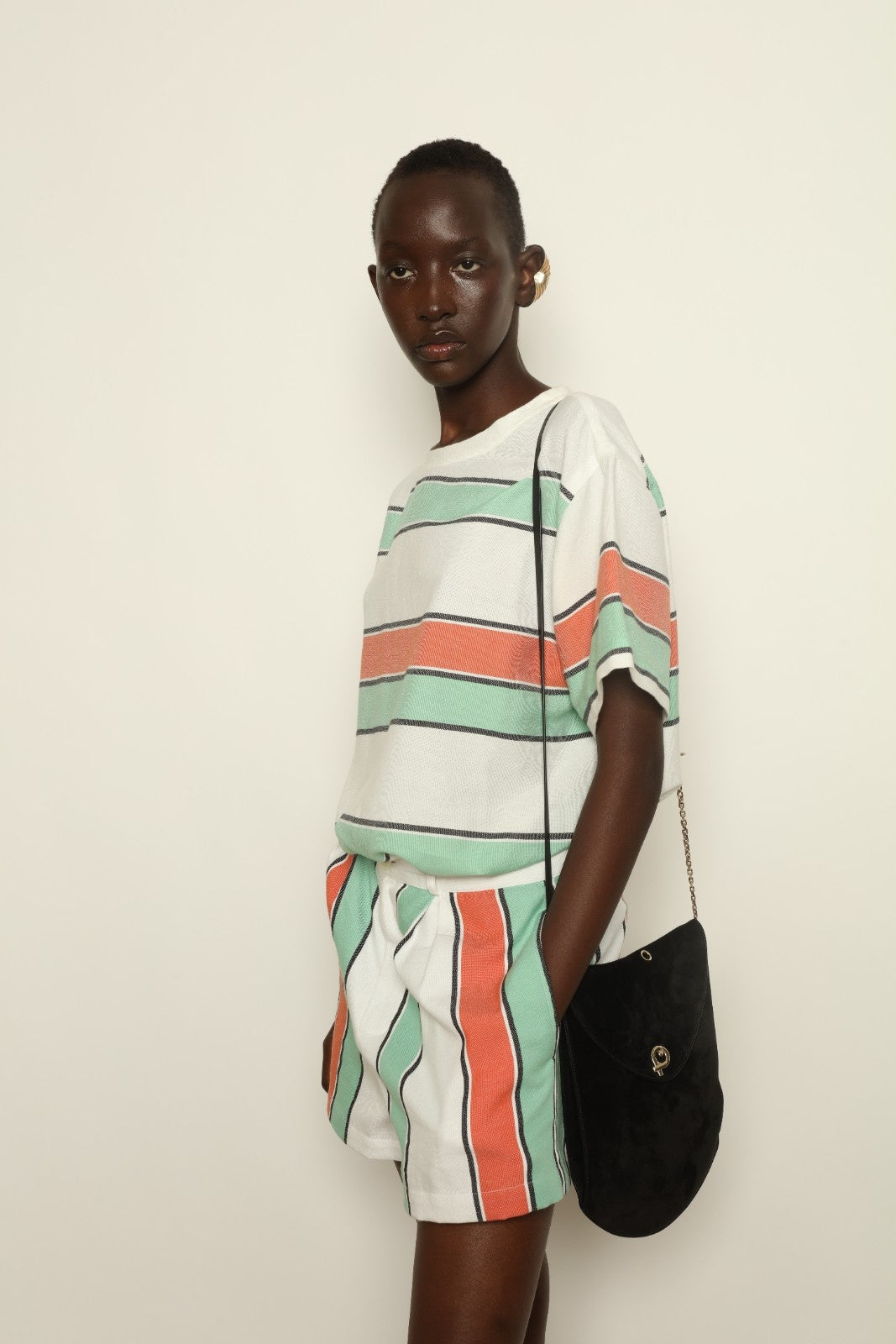 Model is wearing The Pleated Short by Marrakshi Life, part of House of Nomad Stories collection, handwoven artisanal cotton shorts with deep front pleats, high waist, and relaxed sculptural silhouette