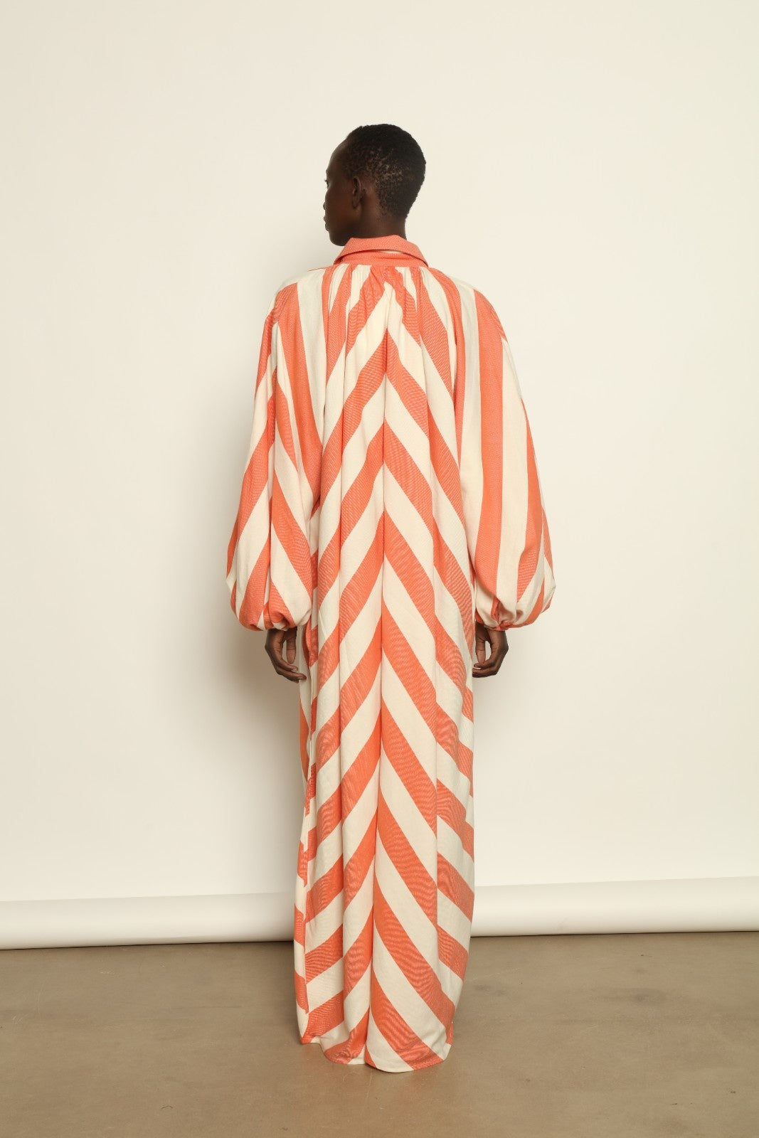 Model is wearing The Touareg Dress with Balloon Sleeve by Marrakshi Life, part of House of Nomad Stories collection, handwoven artisanal cotton dress with sweeping silhouette and dramatic balloon sleeves